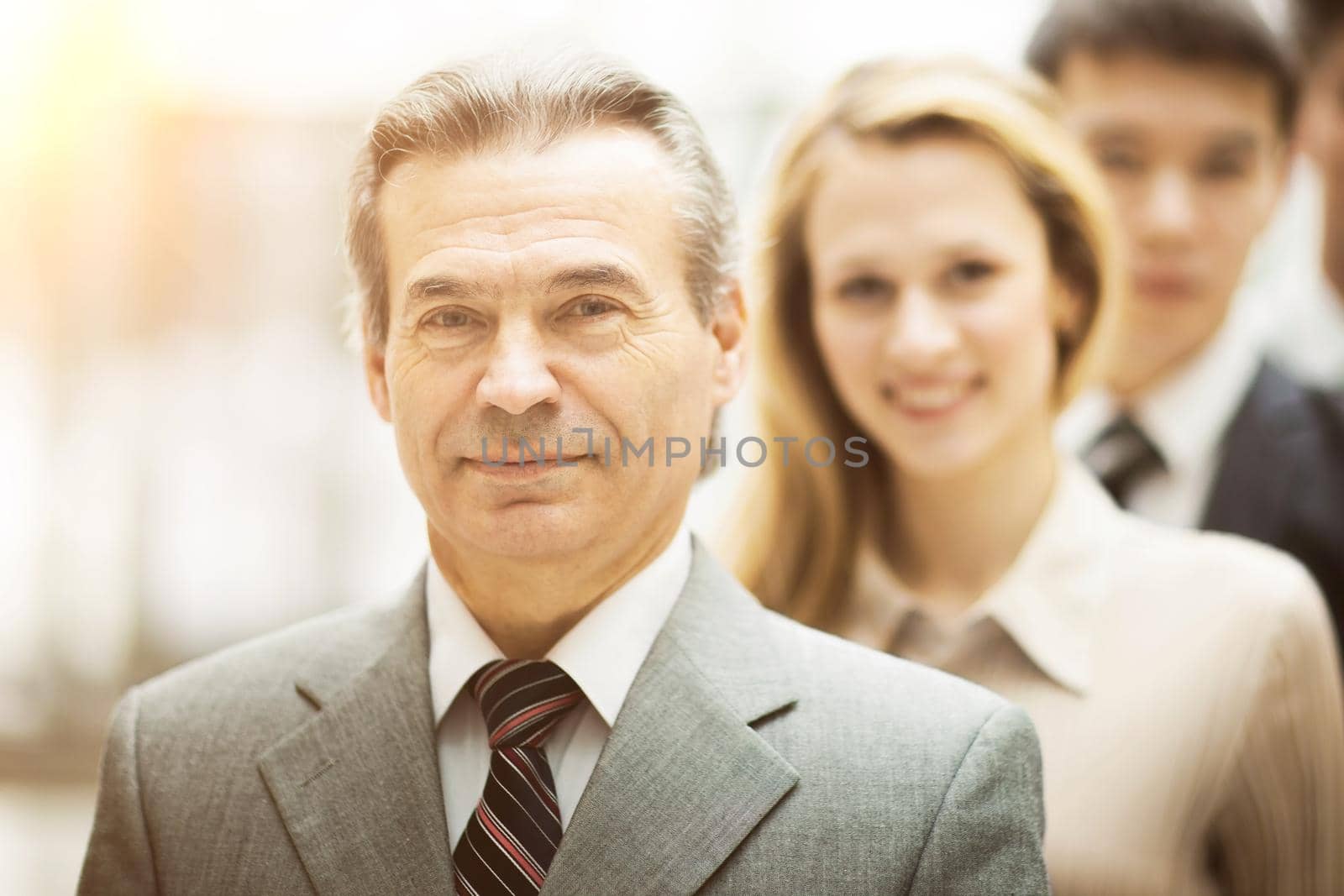 Happy smiling business team standing in a row at office