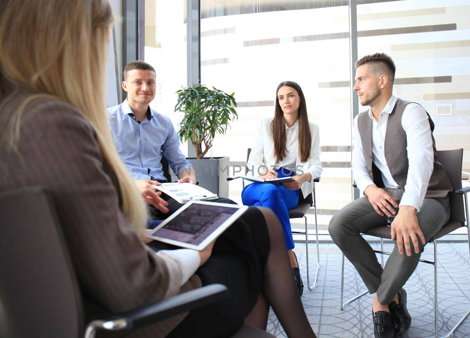 Group of young business professionals having a meeting. Diverse group of young designers smiling during a meeting at the office. by tsyhun