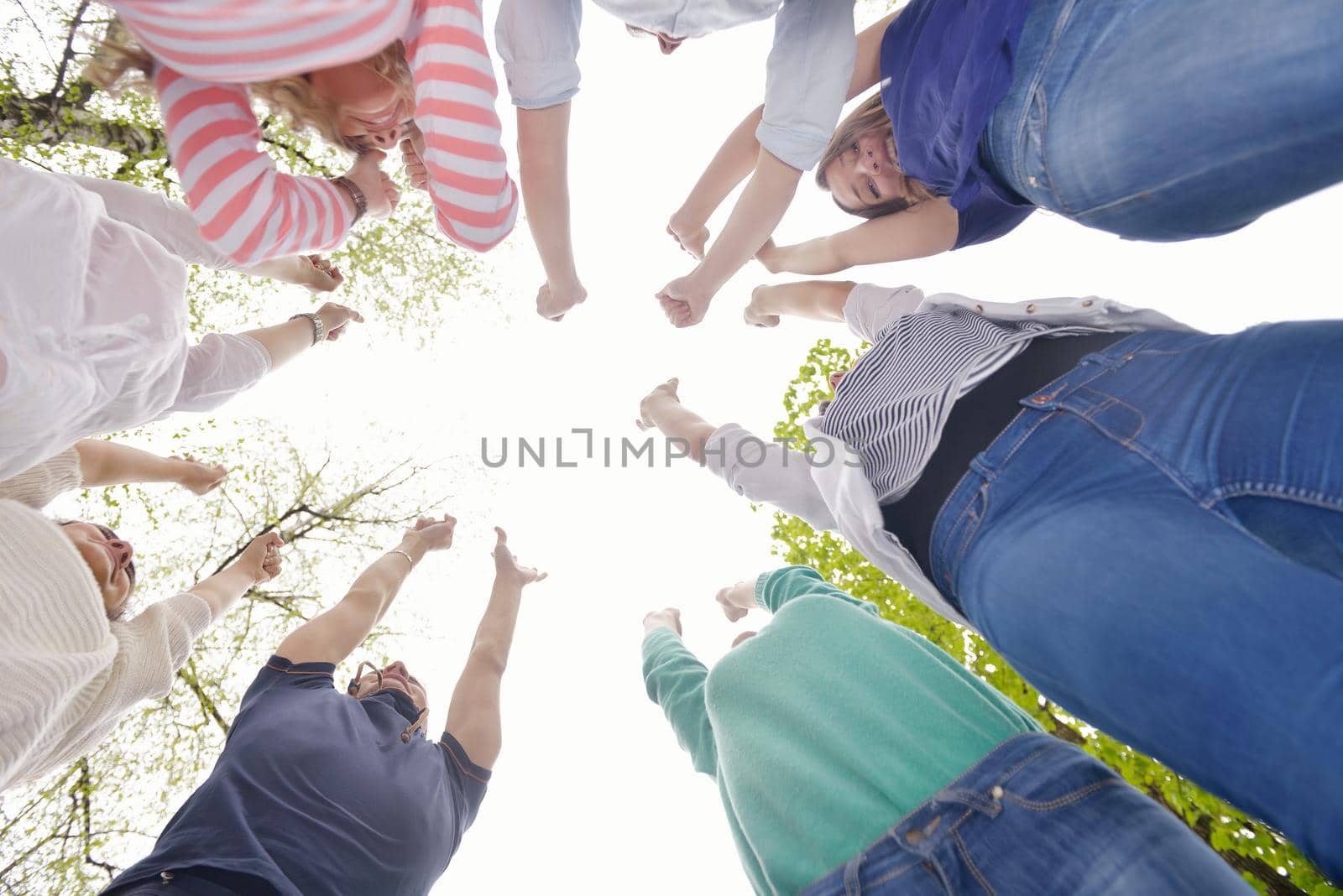 Happy smiling group of young friends staying together outdoor in the park