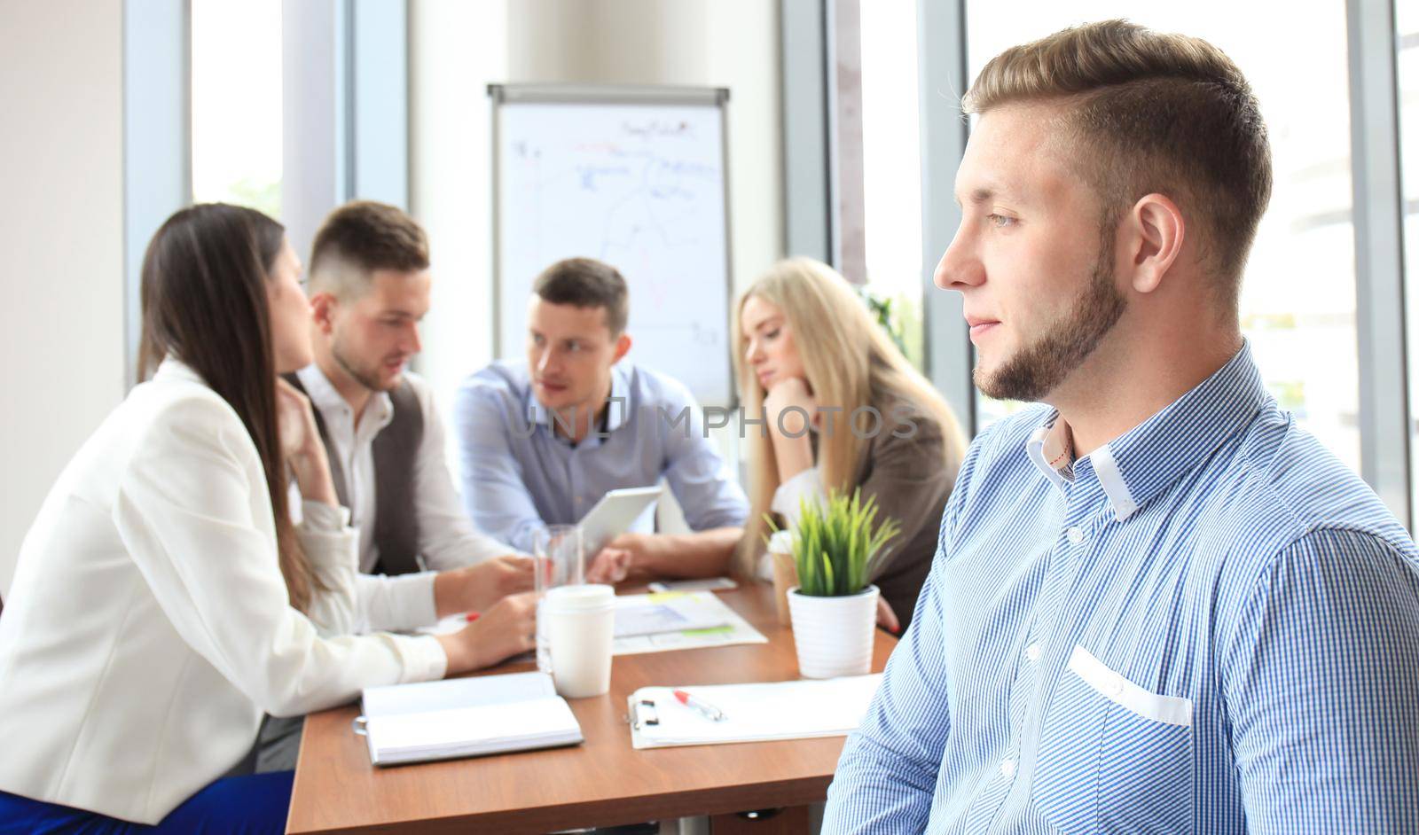 Businessman with colleagues in the background in office