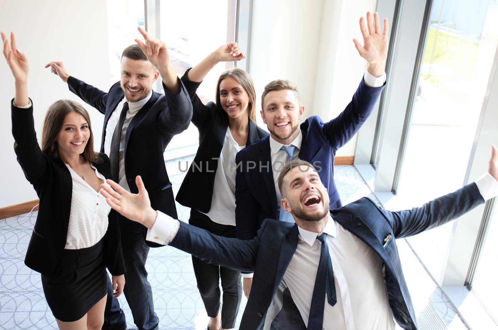 happy business team celebrating victory in office by tsyhun