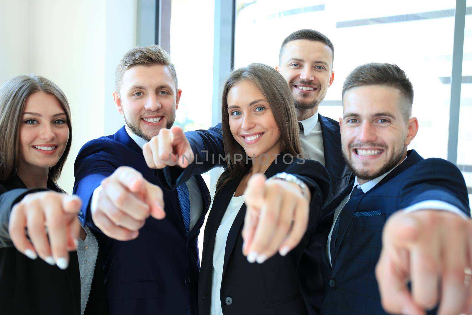 Portrait of excited young business people pointing at you