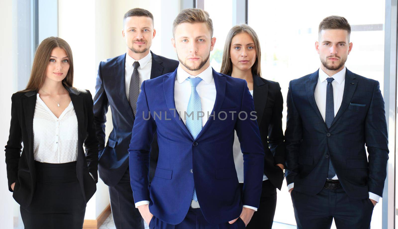 Young businessman standing in office with his collegue on the background by tsyhun