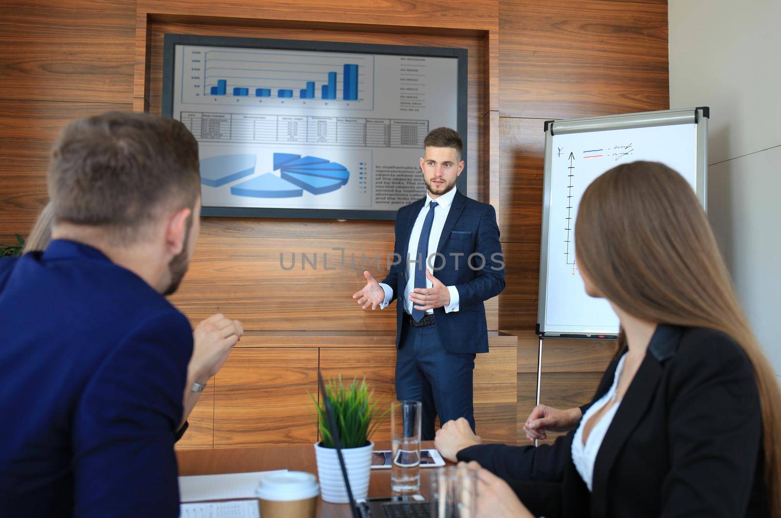 Business training at office, business man presenting successful financial numbers on screen of plasma TV at meeting room