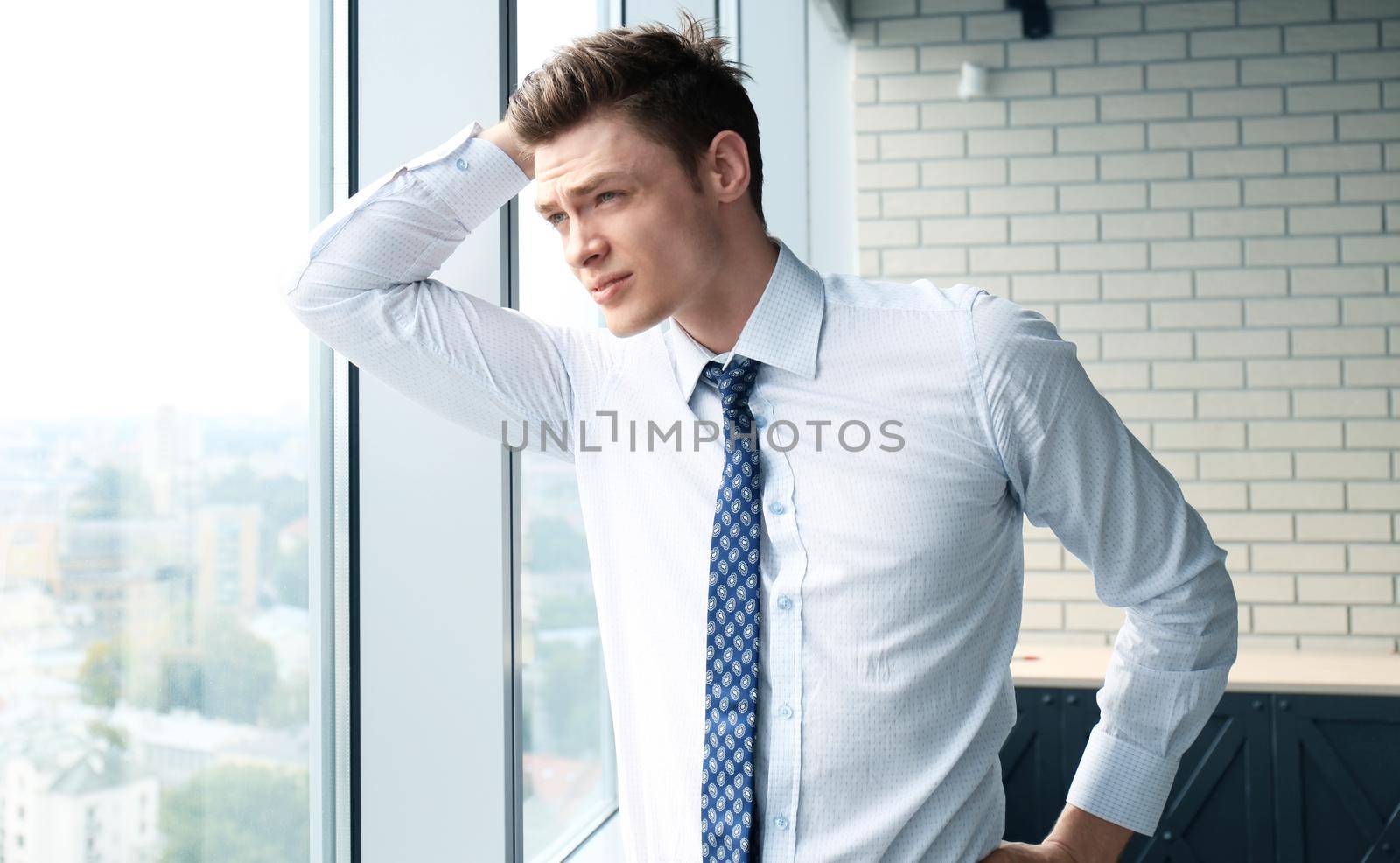 Young handsome businessman smiling in an office environment