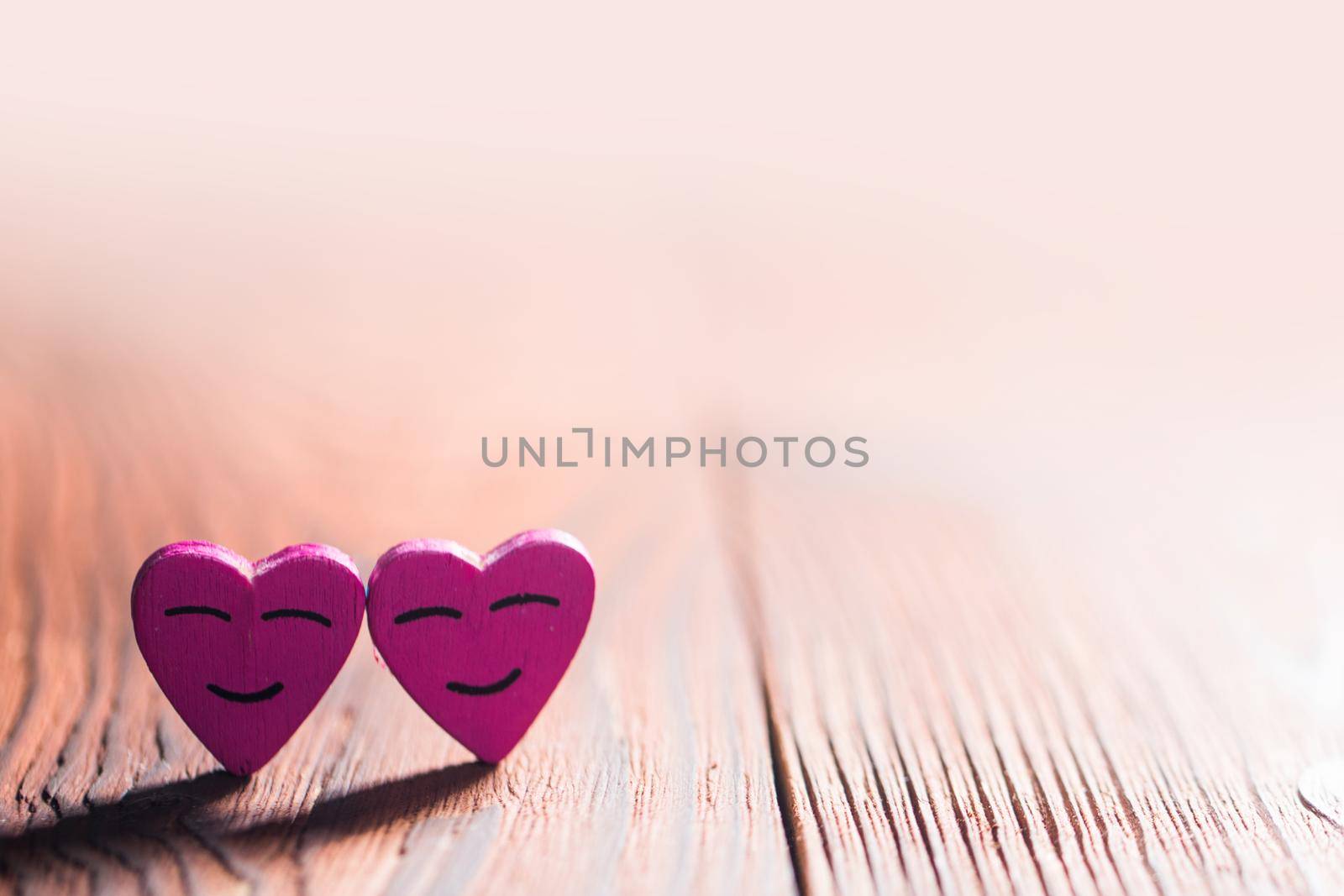 Two smiling pink hearts on wooden background, relationship valentines day concept