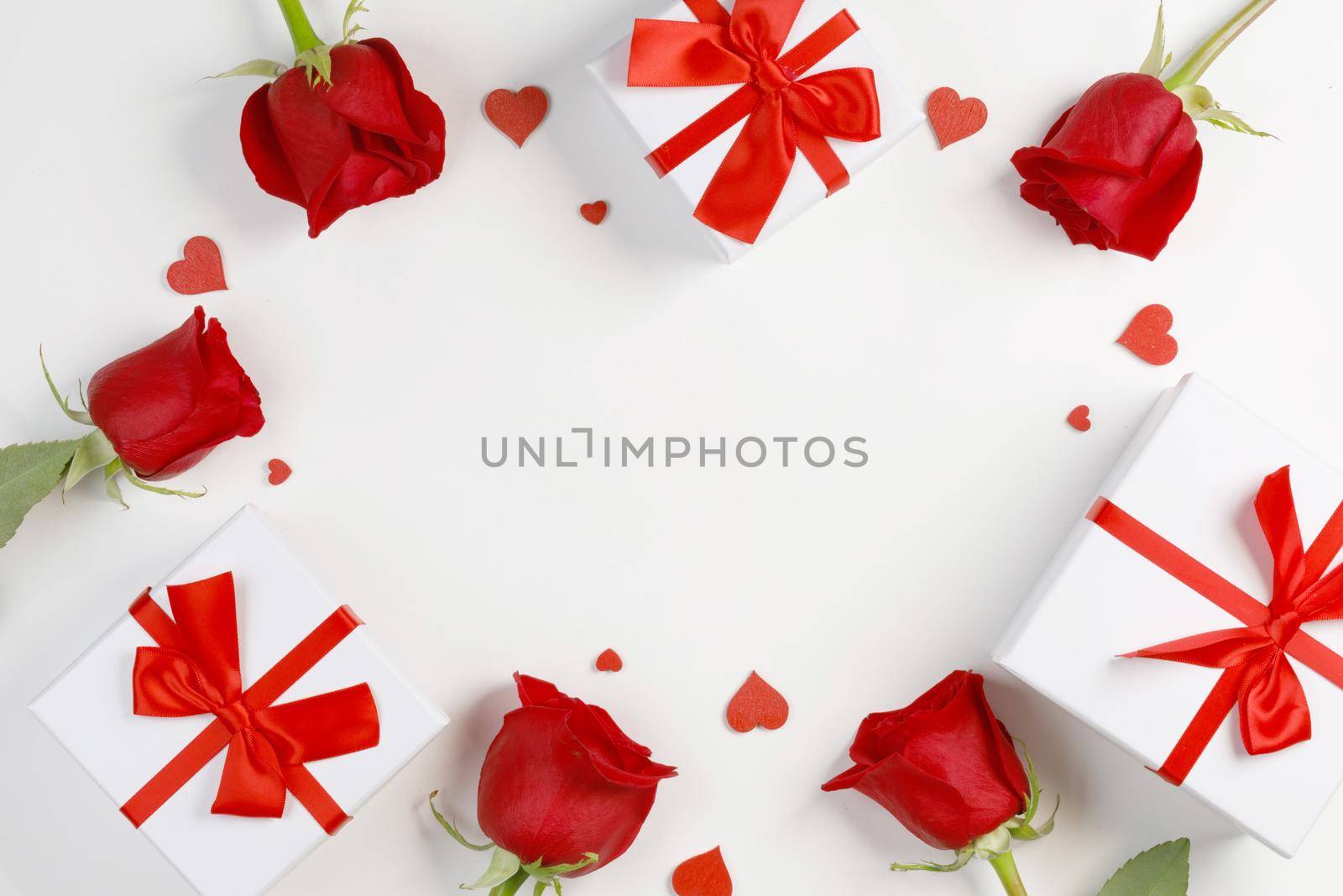 Red rose flowers gifts and red hearts composition on white background top view with copy space. Valentine's day, birthday, wedding, Mother's day concept. Copy space