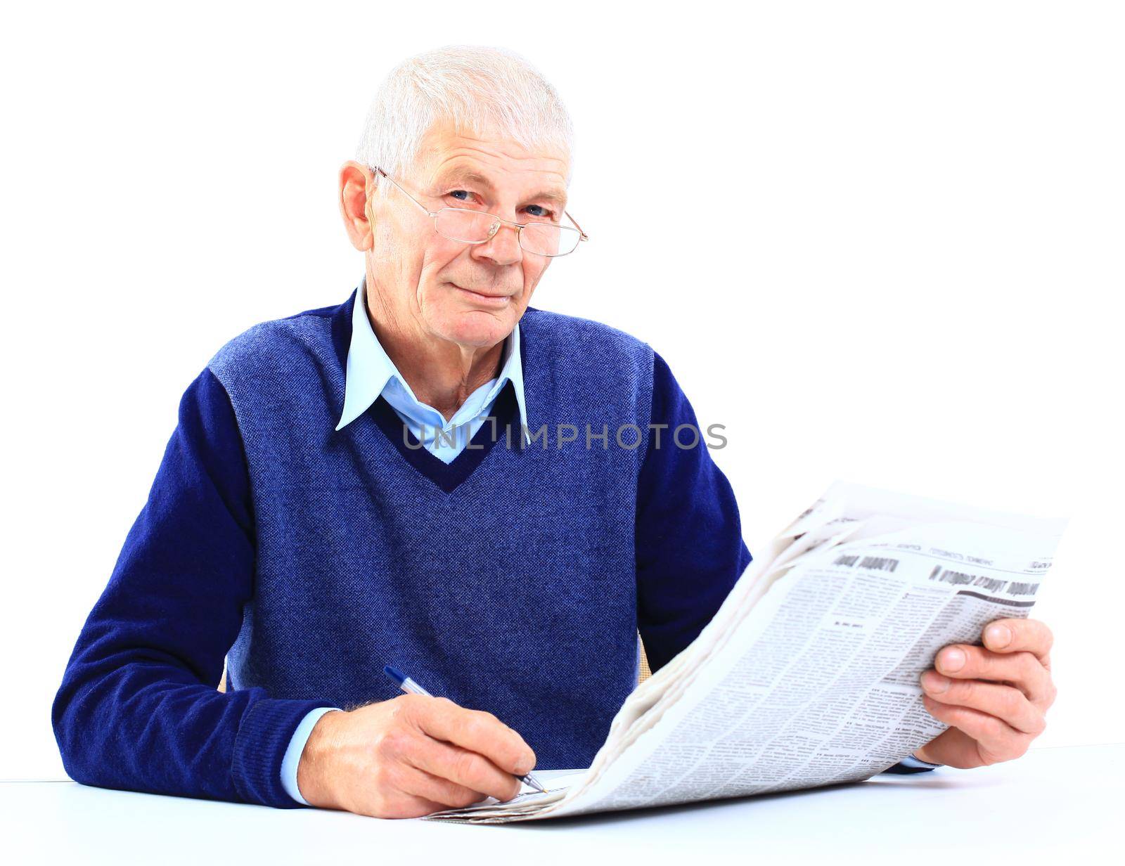 Portrait of an old man solving crosswords in the newspaper