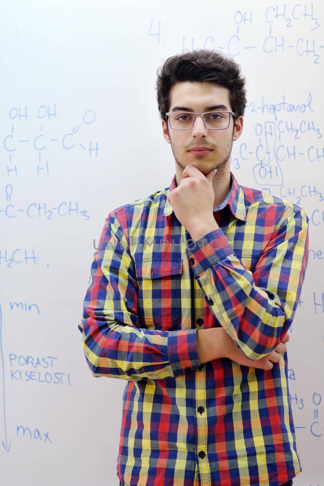 happy young teenage boy portrait in school on chemistry classes and library