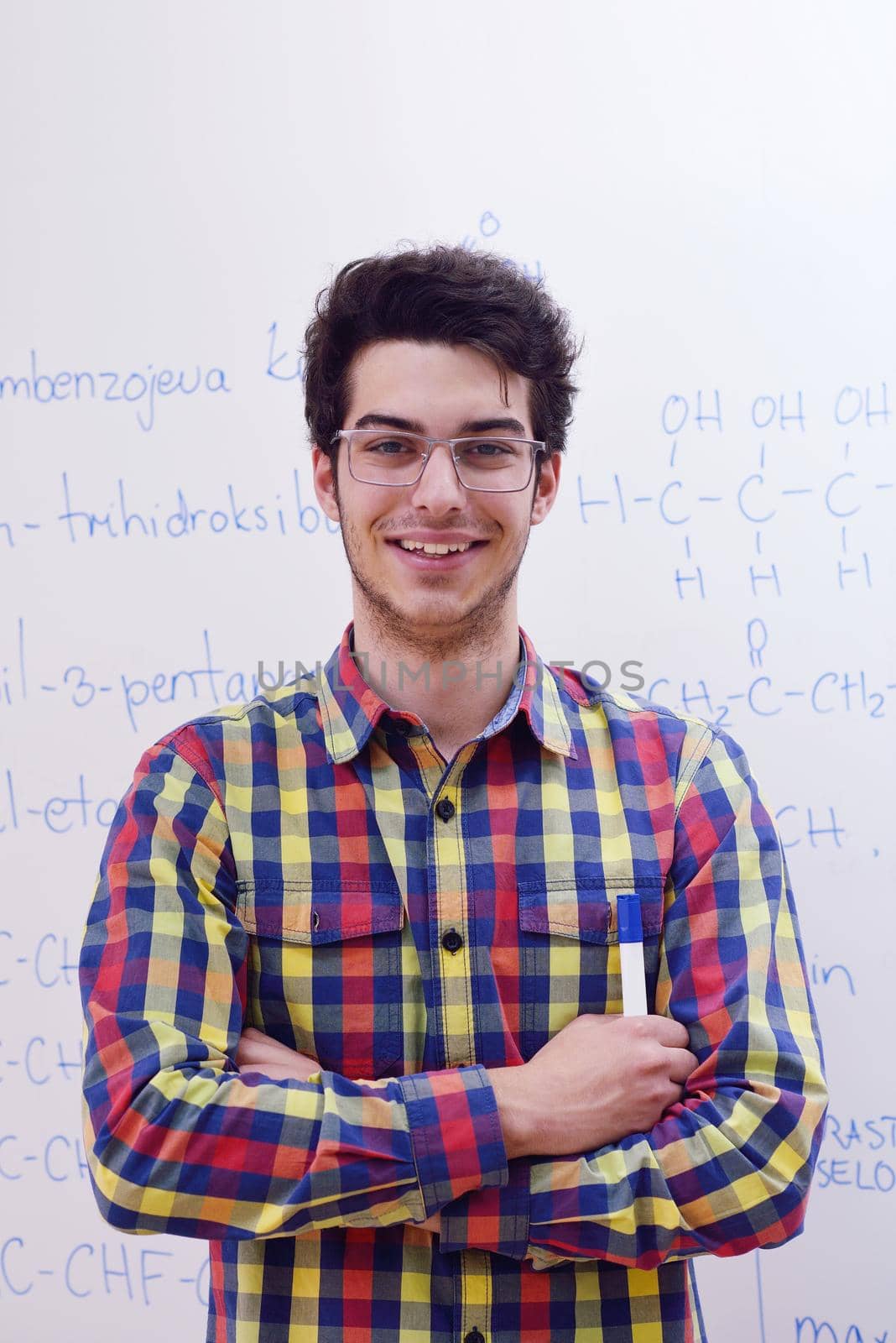 happy young teenage boy portrait in school on chemistry classes and library