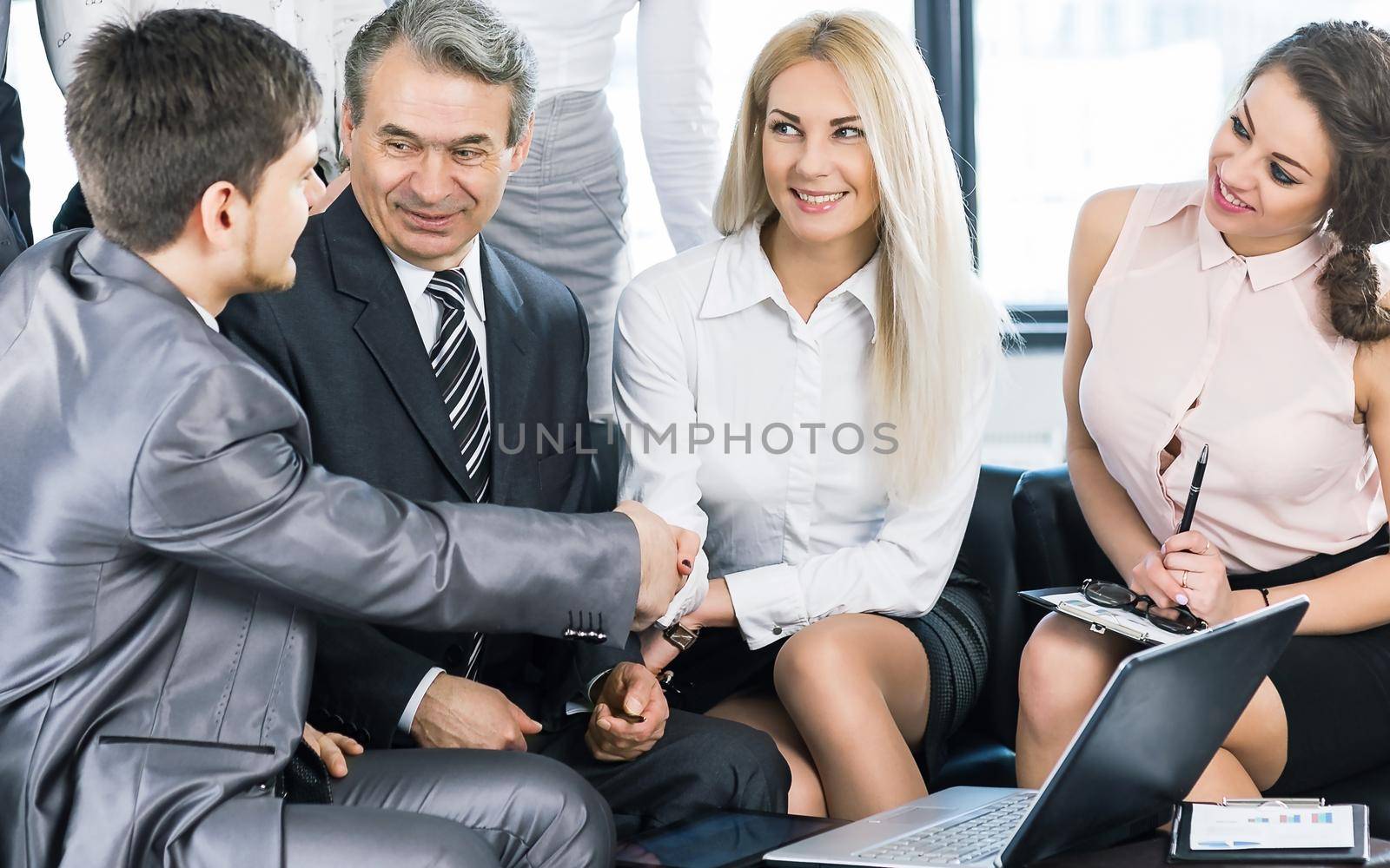 handshake business team of partners in a modern office