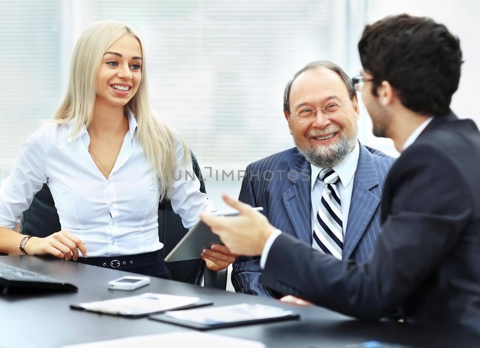 business team is working with financial documents at the office, a discussion between three businessmen