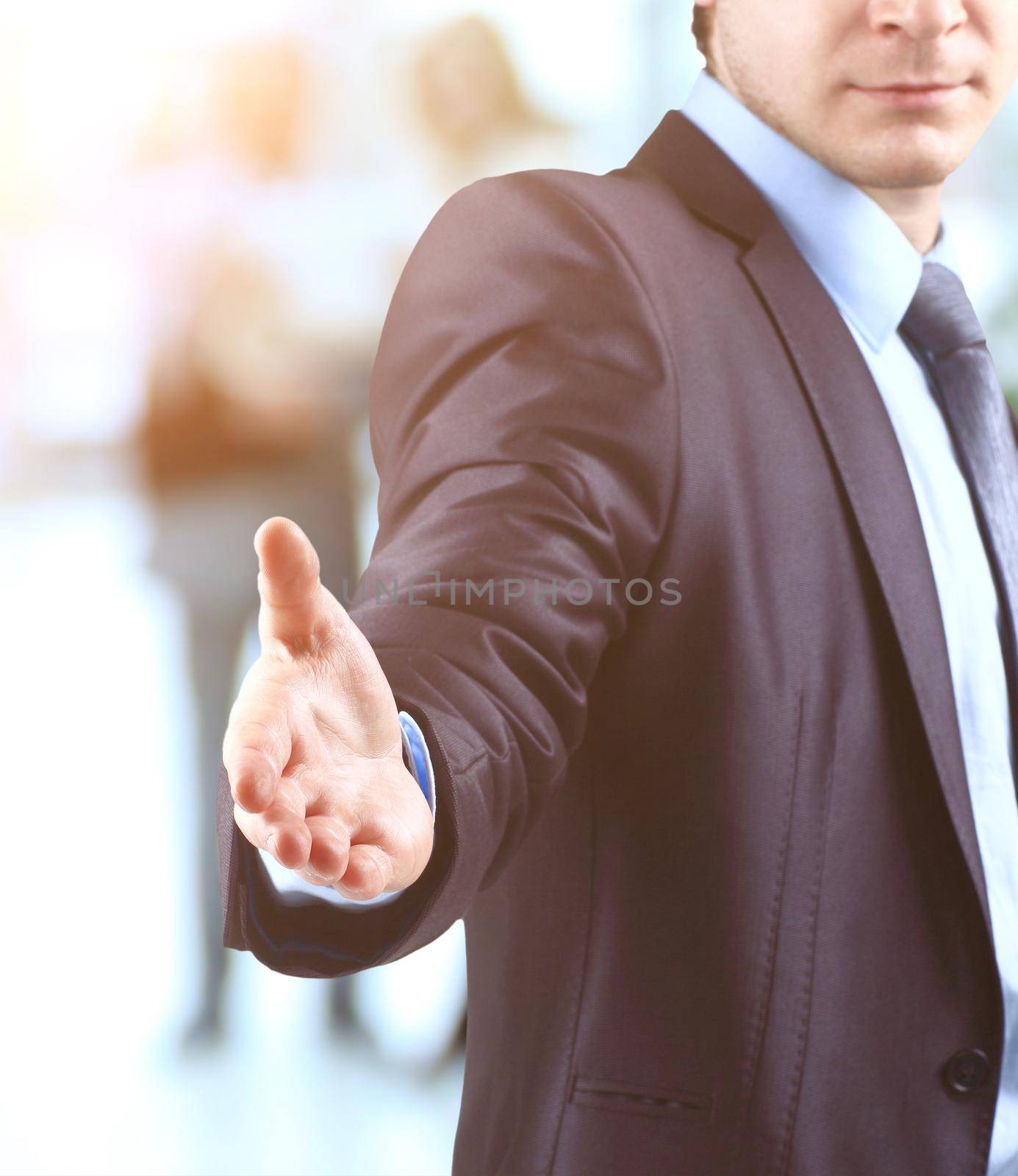 Business man with open hand ready to make a deal on the background diskussiya colleagues by SmartPhotoLab