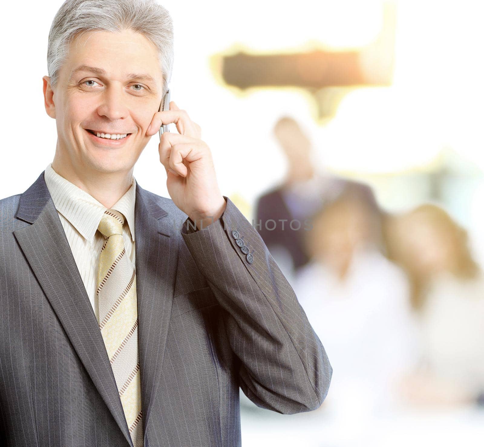 Adult businesswoman talking on the phone makes a deal, team work in the background mode by SmartPhotoLab