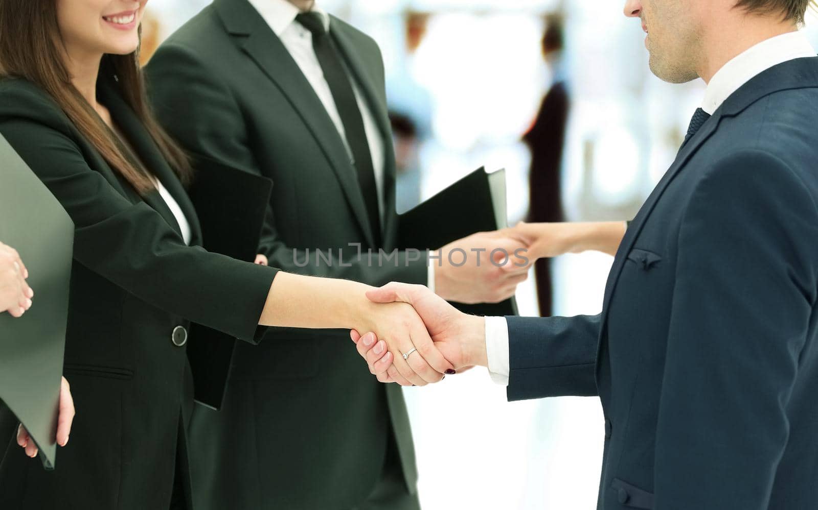 close-up of business partners shaking hands after signing of the contract against the background of the office