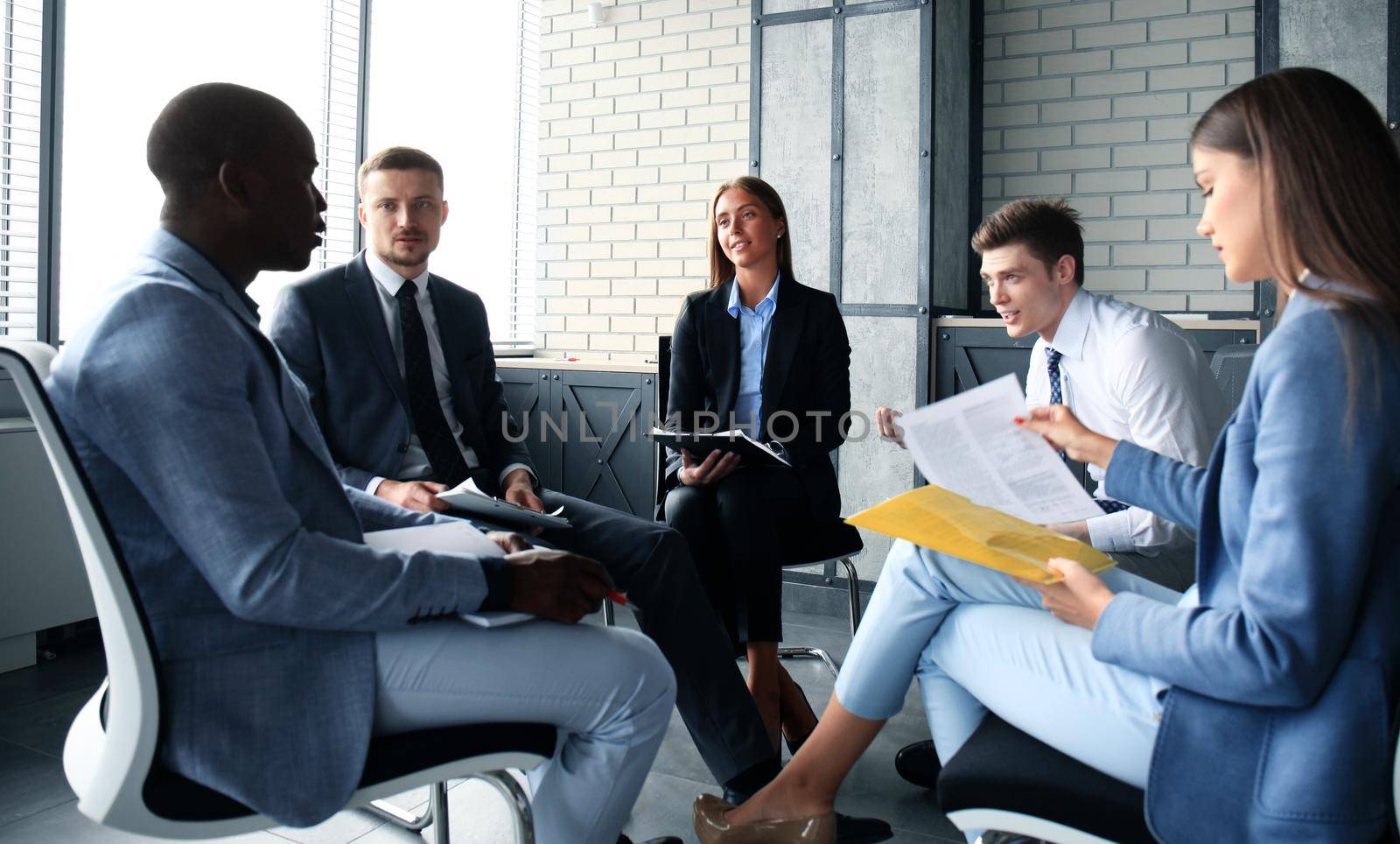 Creative business people meeting in circle of chairs by tsyhun