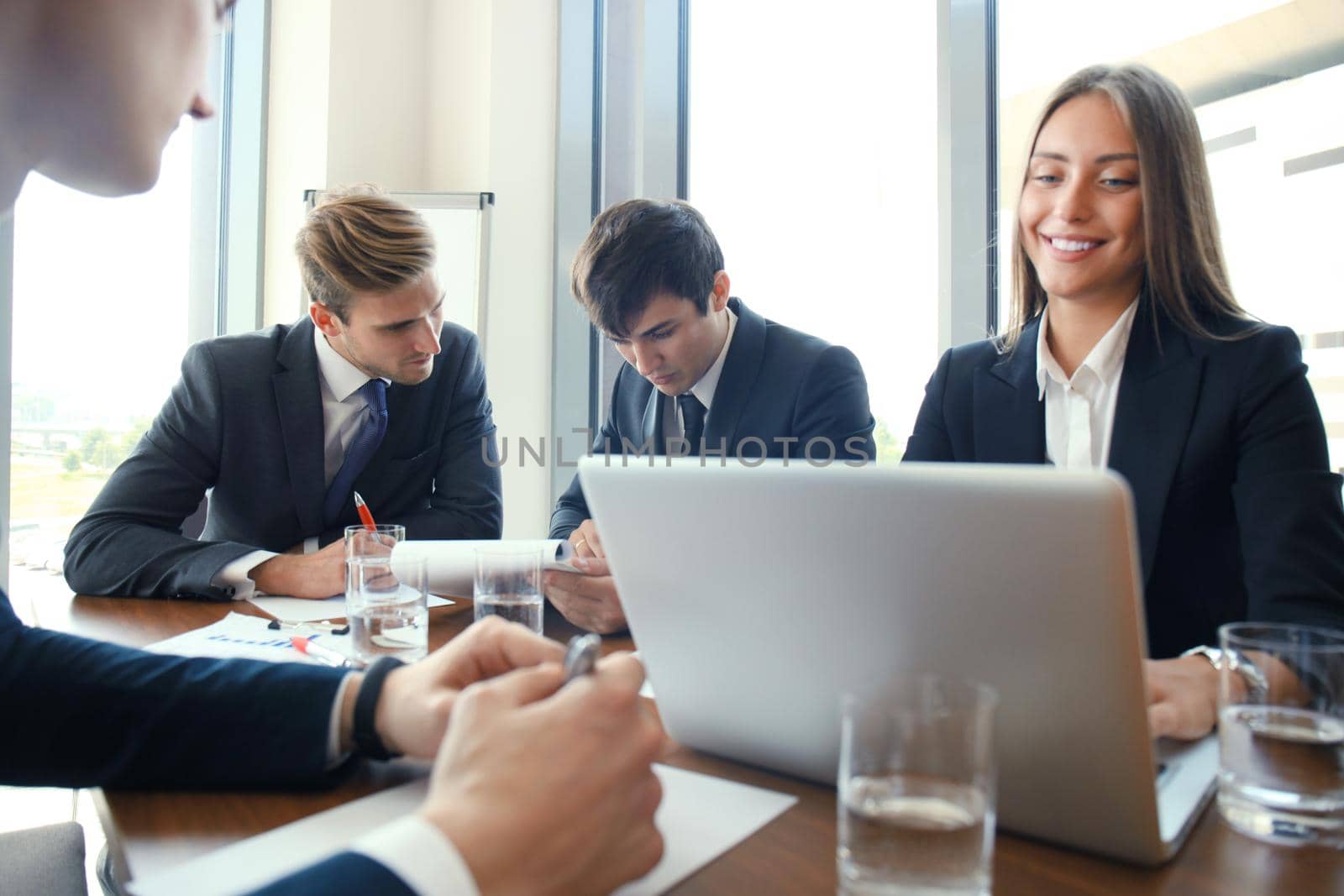 Businesspeople discussing together in conference room during meeting at office. by tsyhun