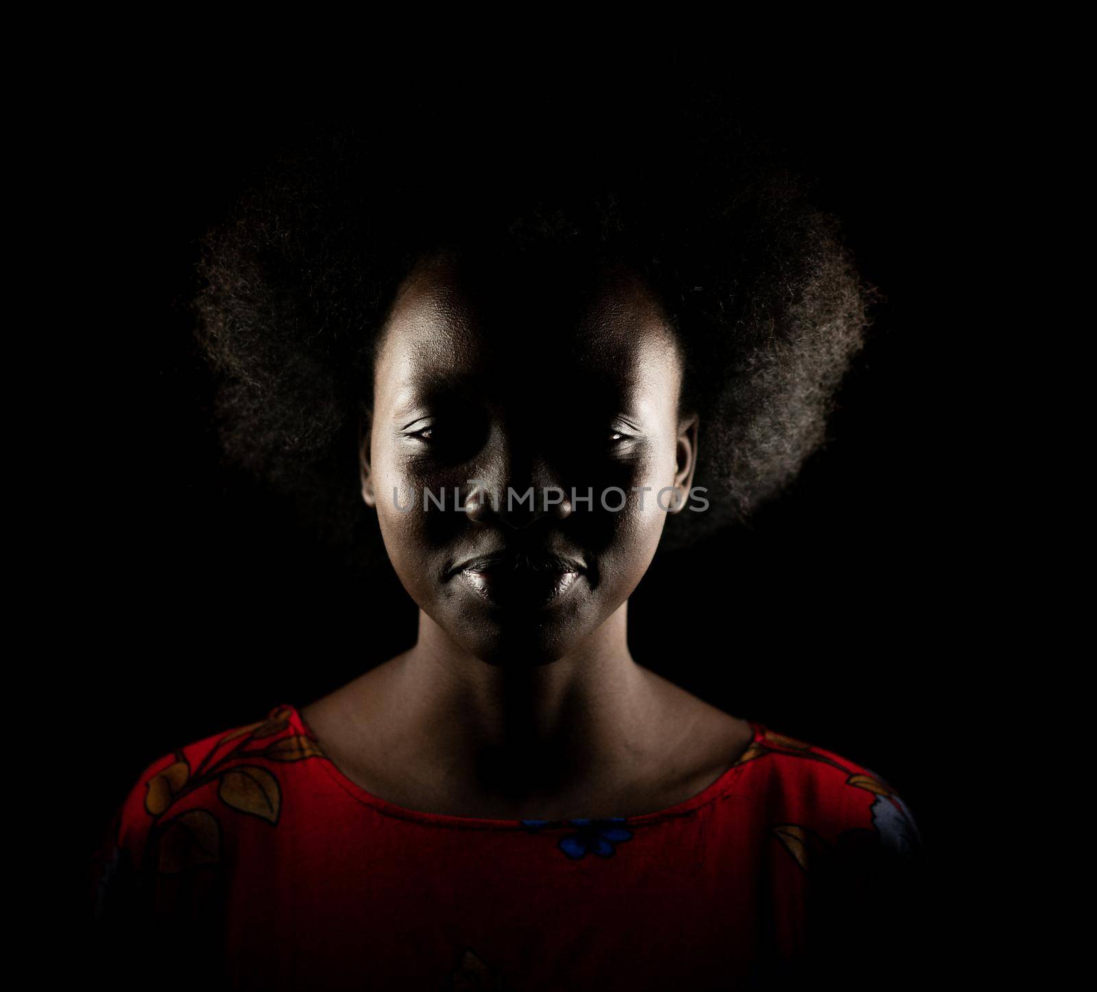 Dark portrait of young black woman in studio