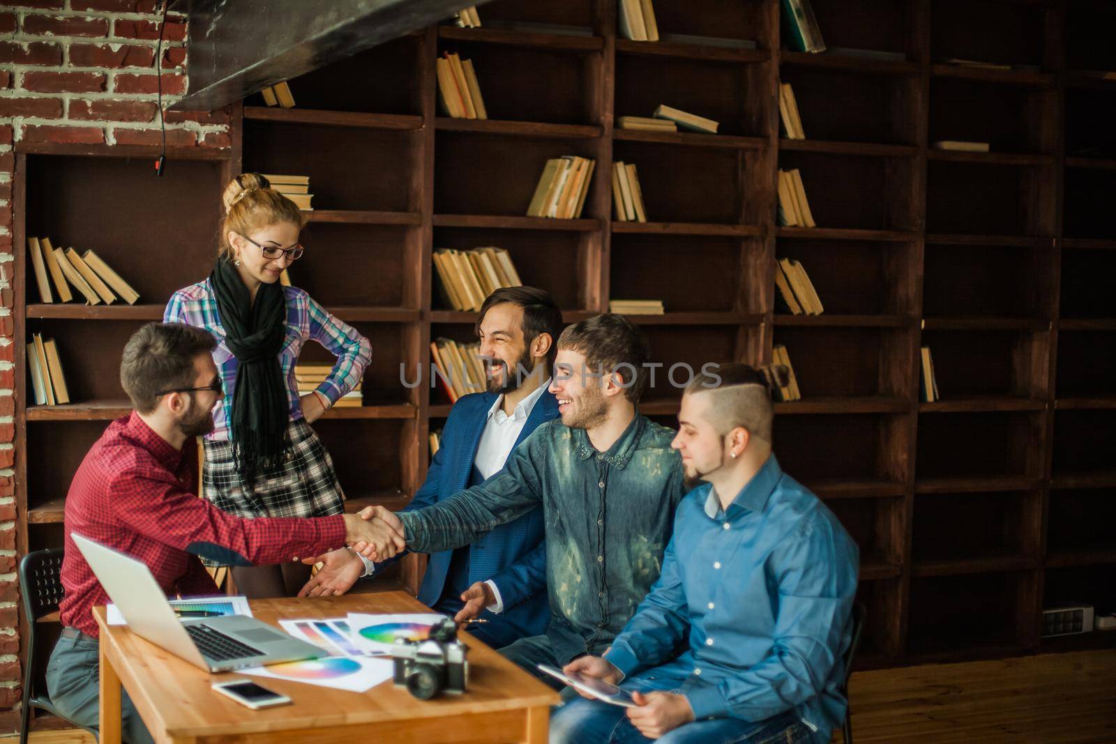 advertising Manager with a handshake greets the customer in a modern office