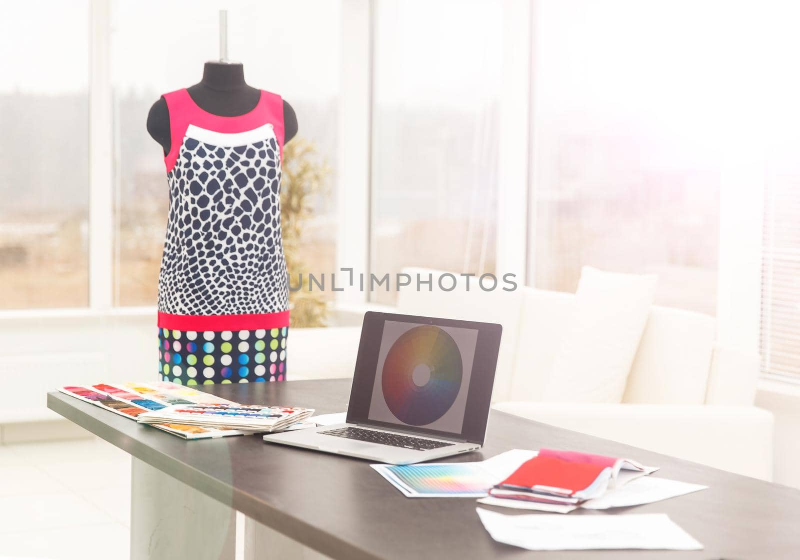 workplace in modern tailoring and a palette of fabric colors on the laptop to create new styles of clothing