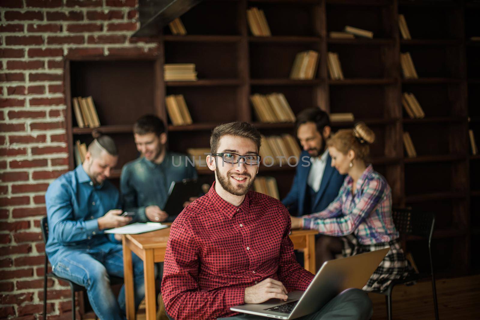 in the foreground the successful employee of the company with laptop on the background of business team