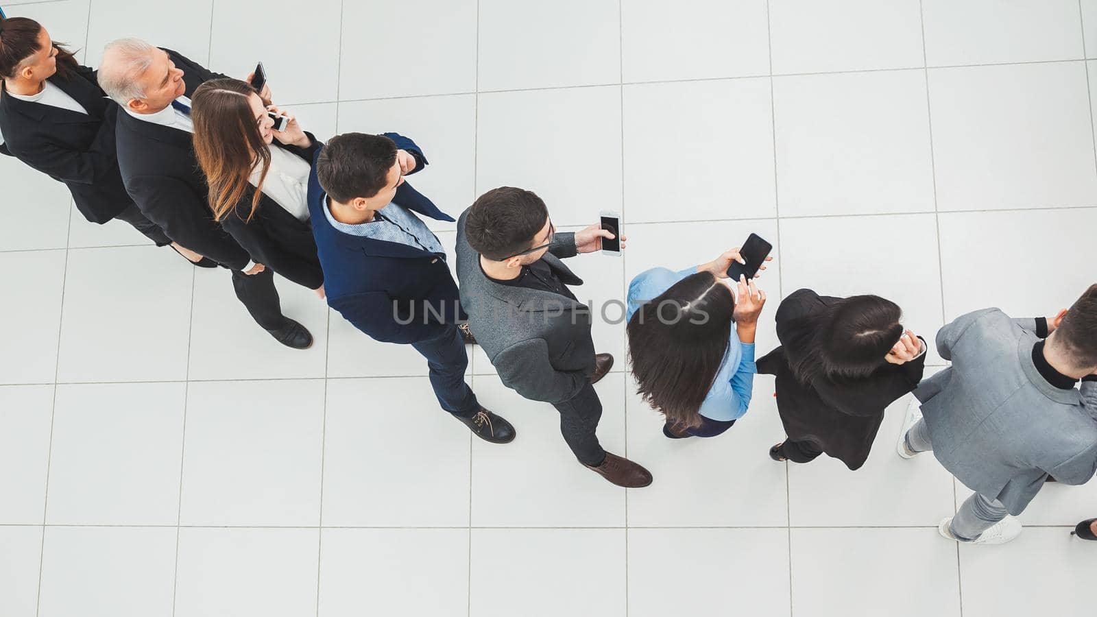 top view. a group of business people looking at their smartphon screens. by SmartPhotoLab