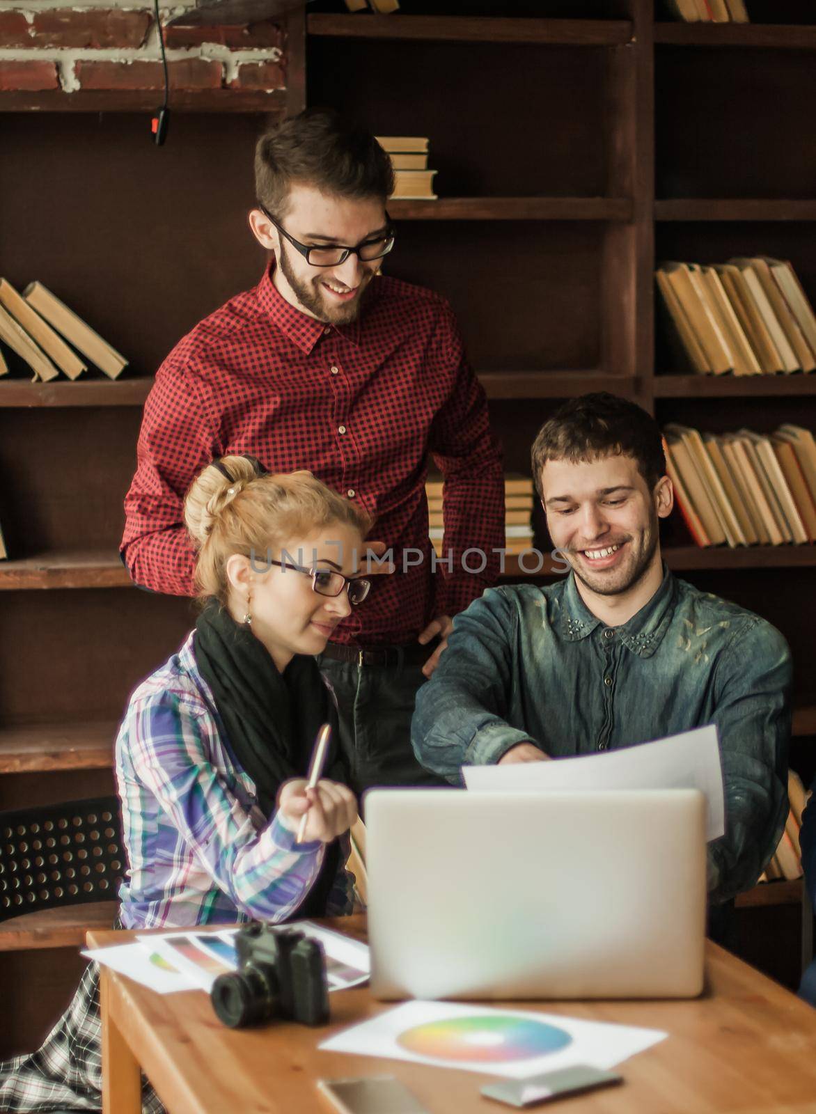 friendly team of copywriters in the workplace in modern office by SmartPhotoLab