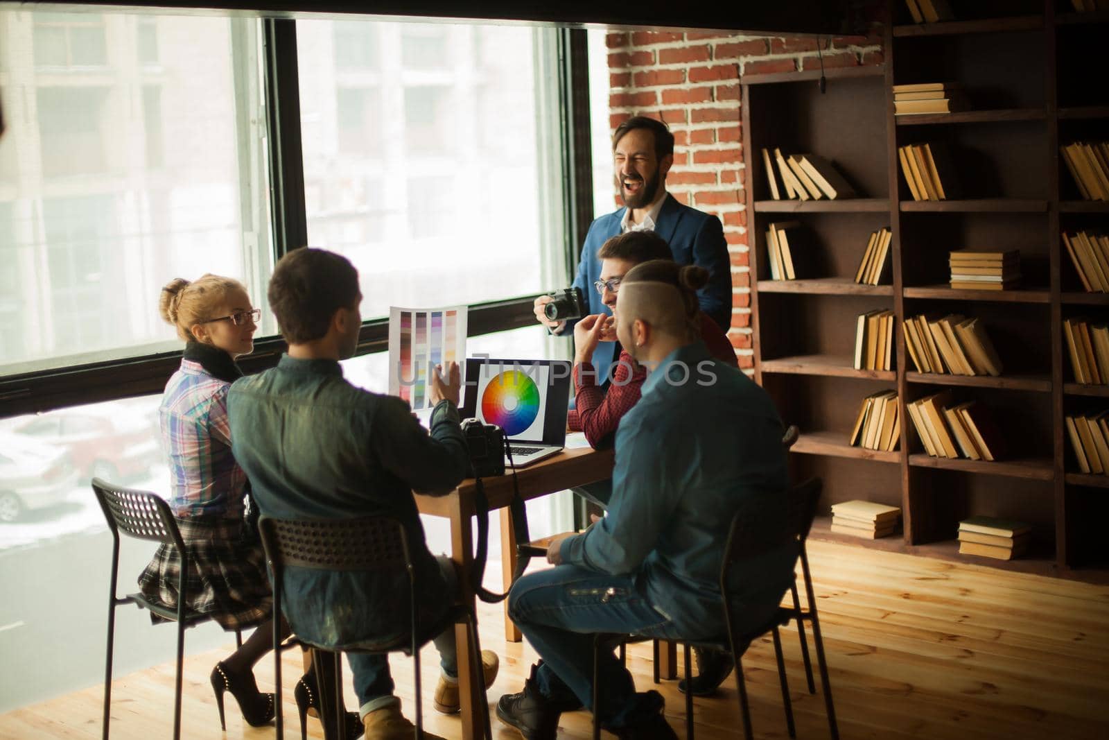 group of creative designers discussing a new color palette in the workplace in a modern office
