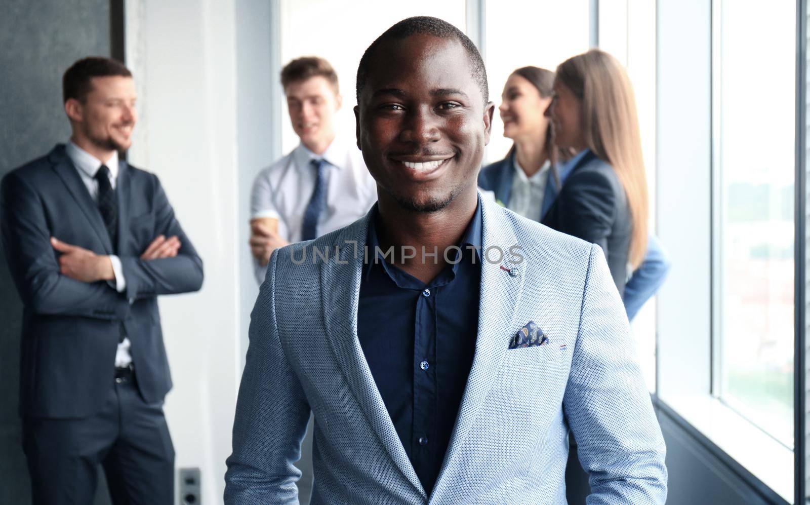 Young businessman standing in office with his collegue on the background