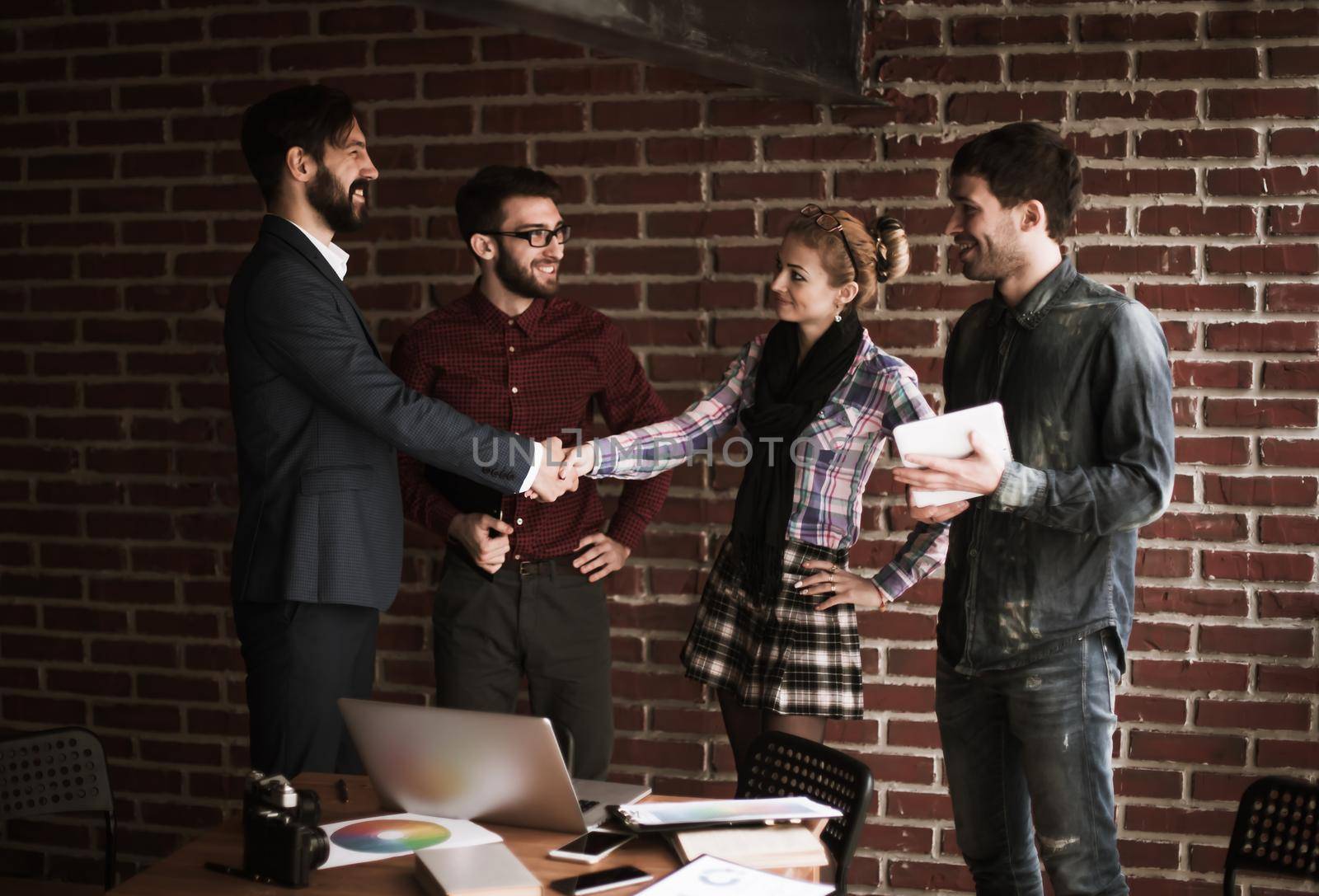 business team and the Manager with a handshake greeted the customer in a modern office