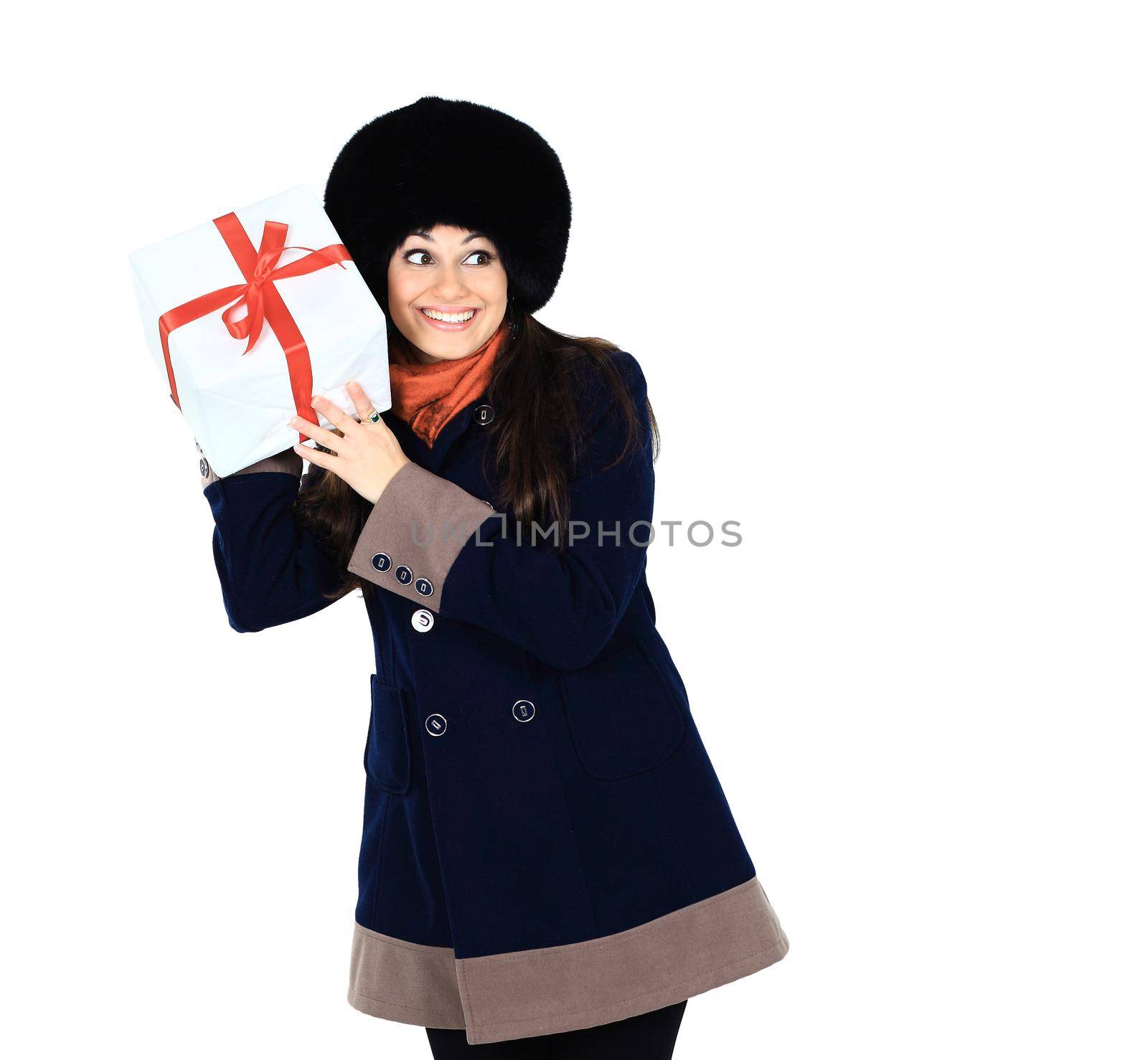 Beautiful woman with a gift in the hands, trying to guess what's in the box, isolated on a white background