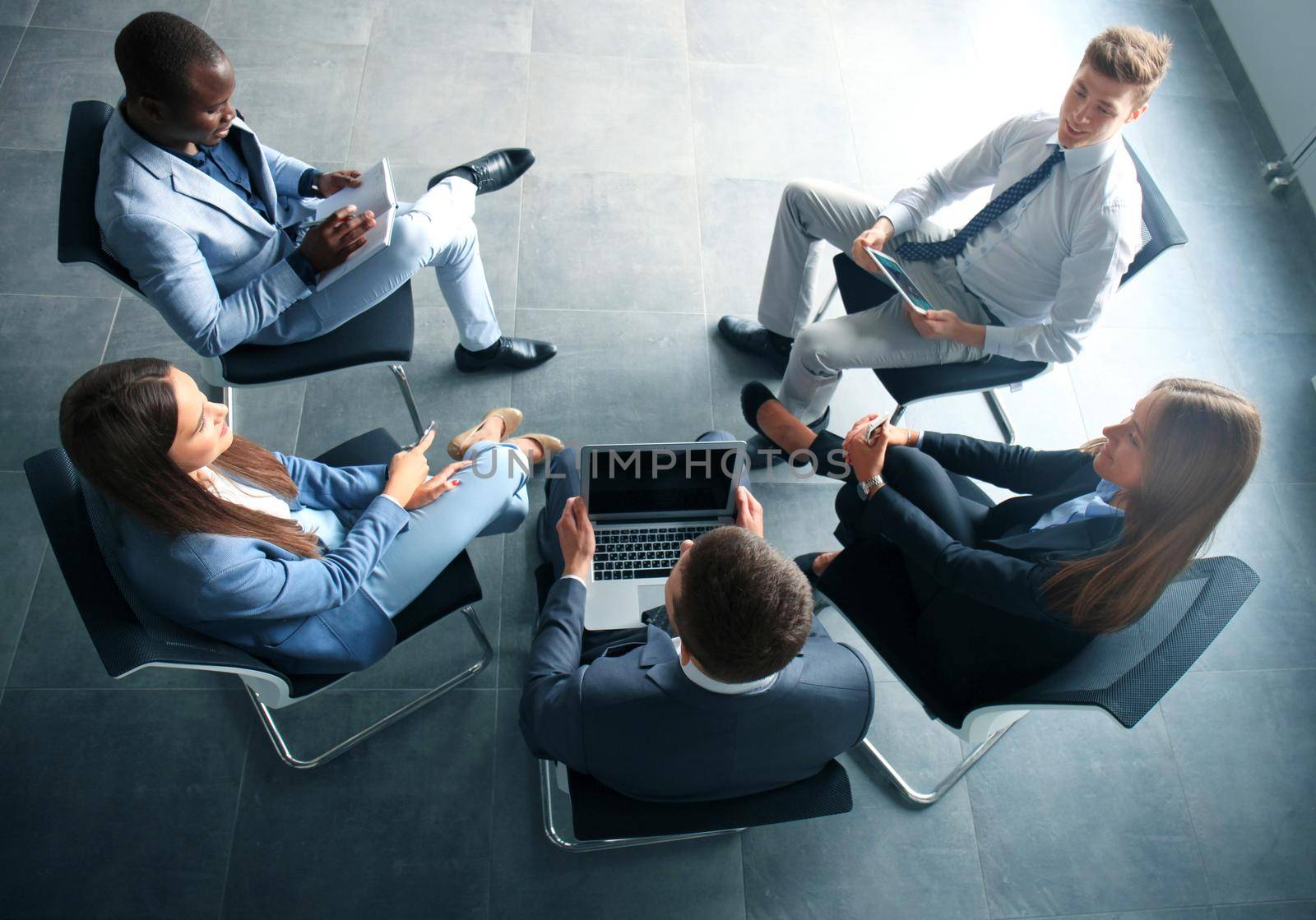 Creative business people meeting in circle of chairs by tsyhun