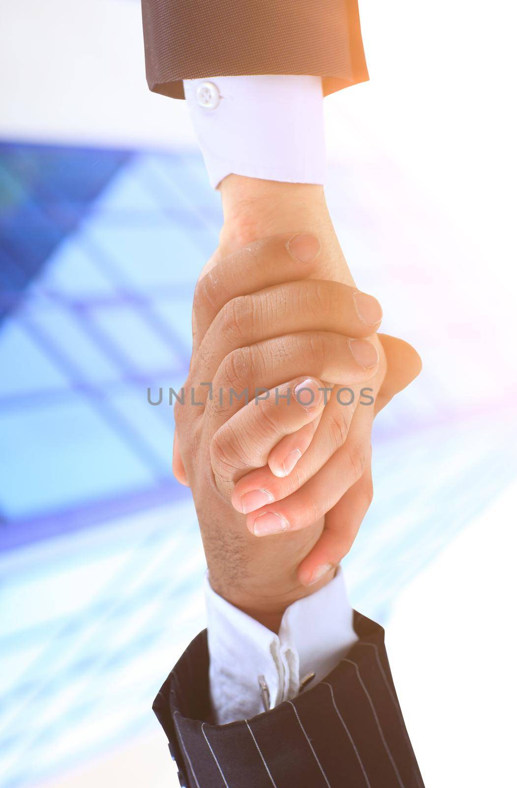 Make a deal. Handshake shot from a low angle against a background of the business center on a sunny day