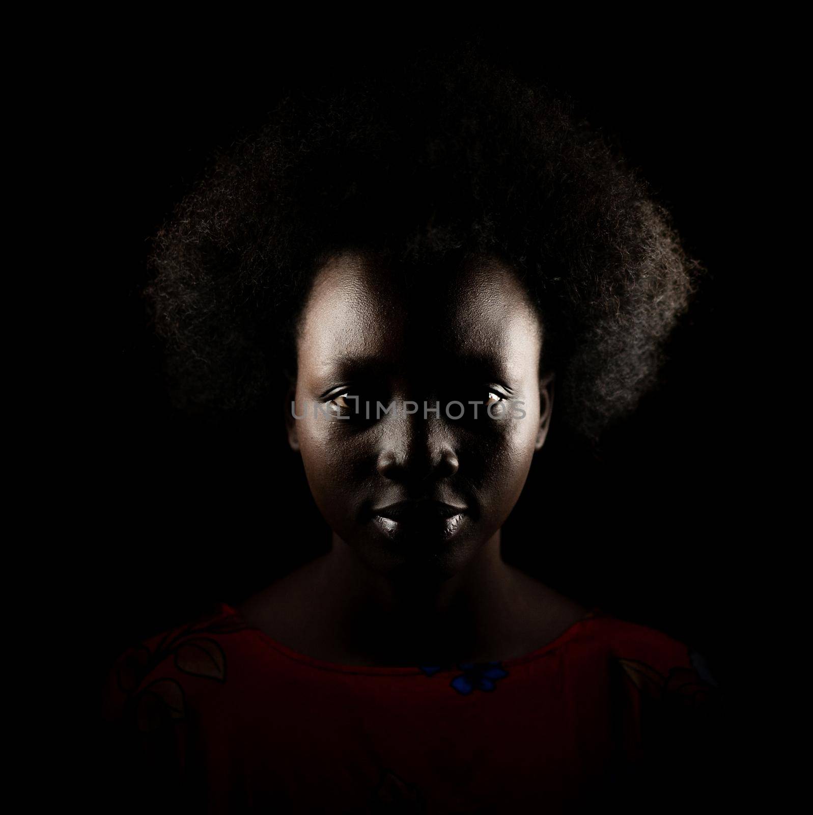 Dark portrait of young black woman in studio