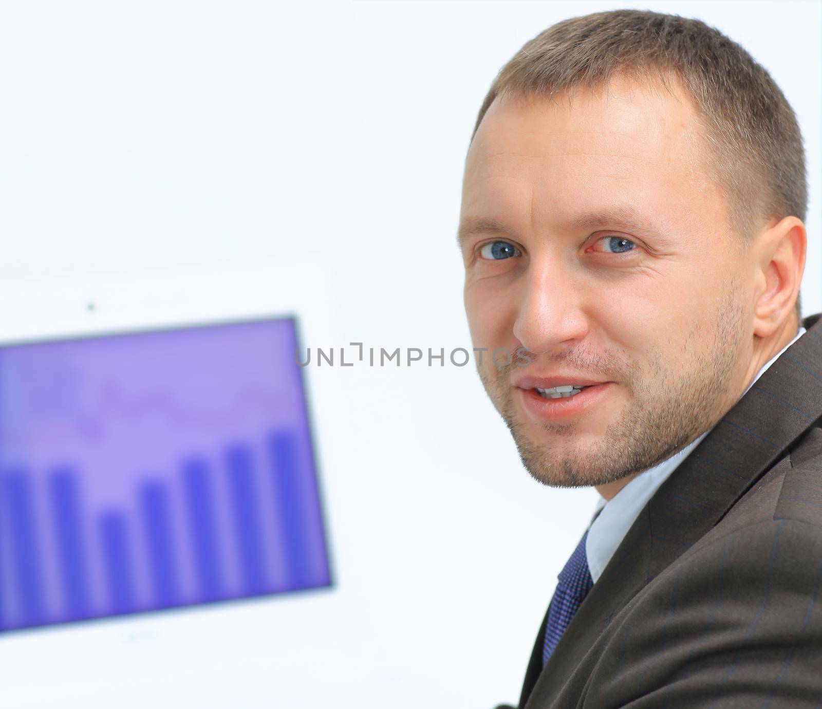 Closeup portrait of confident business man using laptop while looking at you by tsyhun