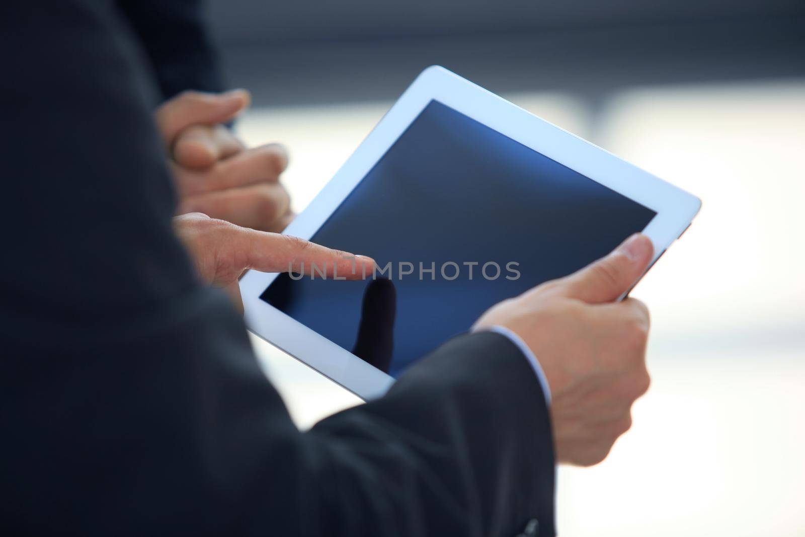 Business person analyzing financial statistics displayed on the tablet screen by tsyhun