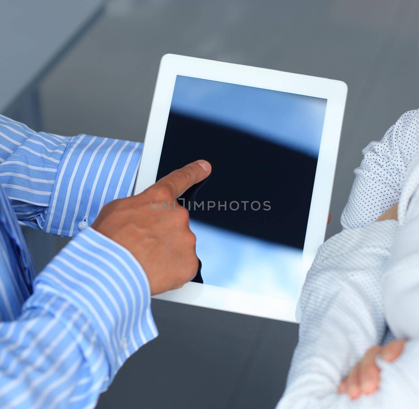 Closeup two modern business people working with digital tablet by tsyhun