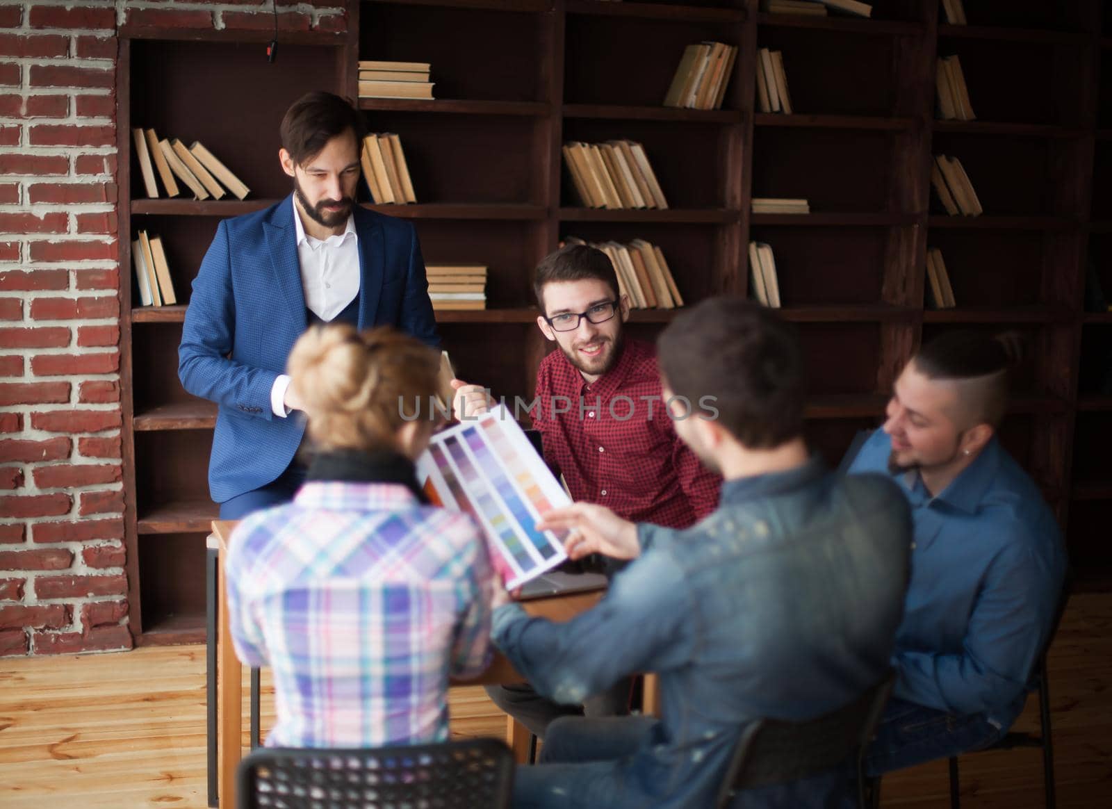 group of creative designers discussing a new color palette in the workplace in a modern office. the photo has a empty space for your text