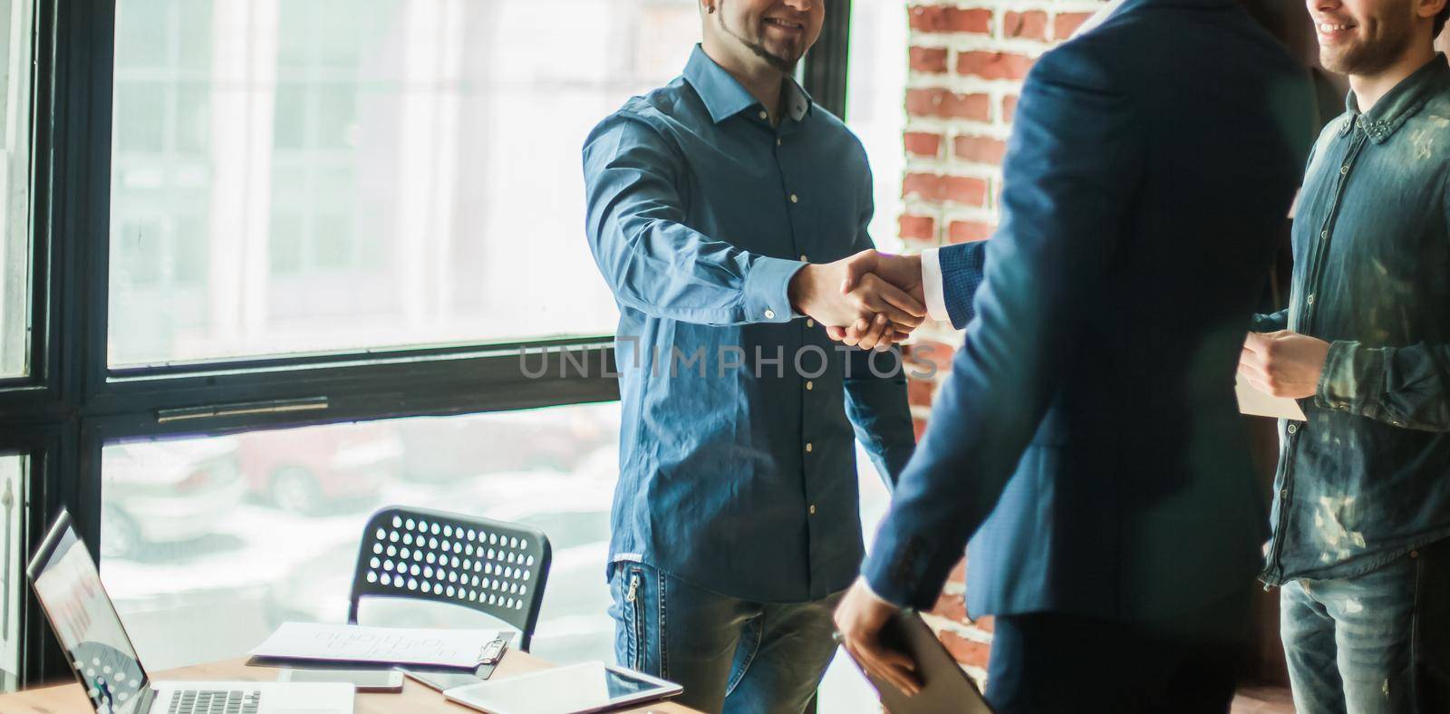 Manager of the company welcomes the customer with a handshake in by SmartPhotoLab