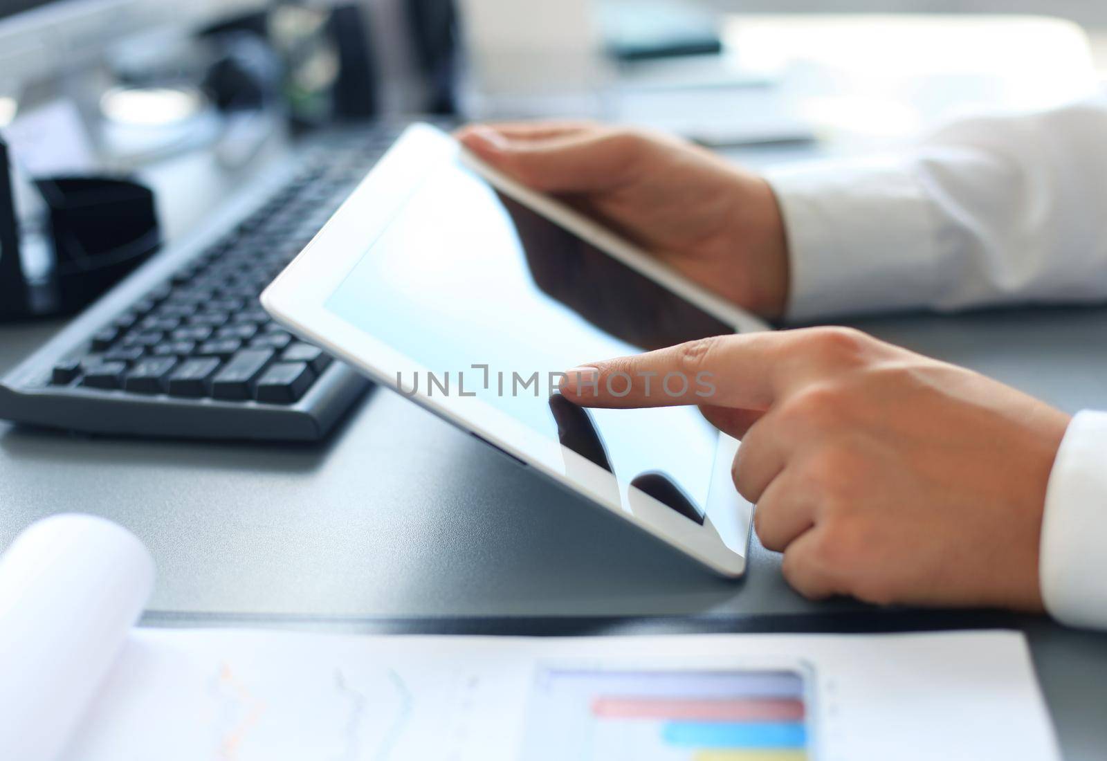 Image of human hand pointing at touchscreen in working environment at meeting by tsyhun