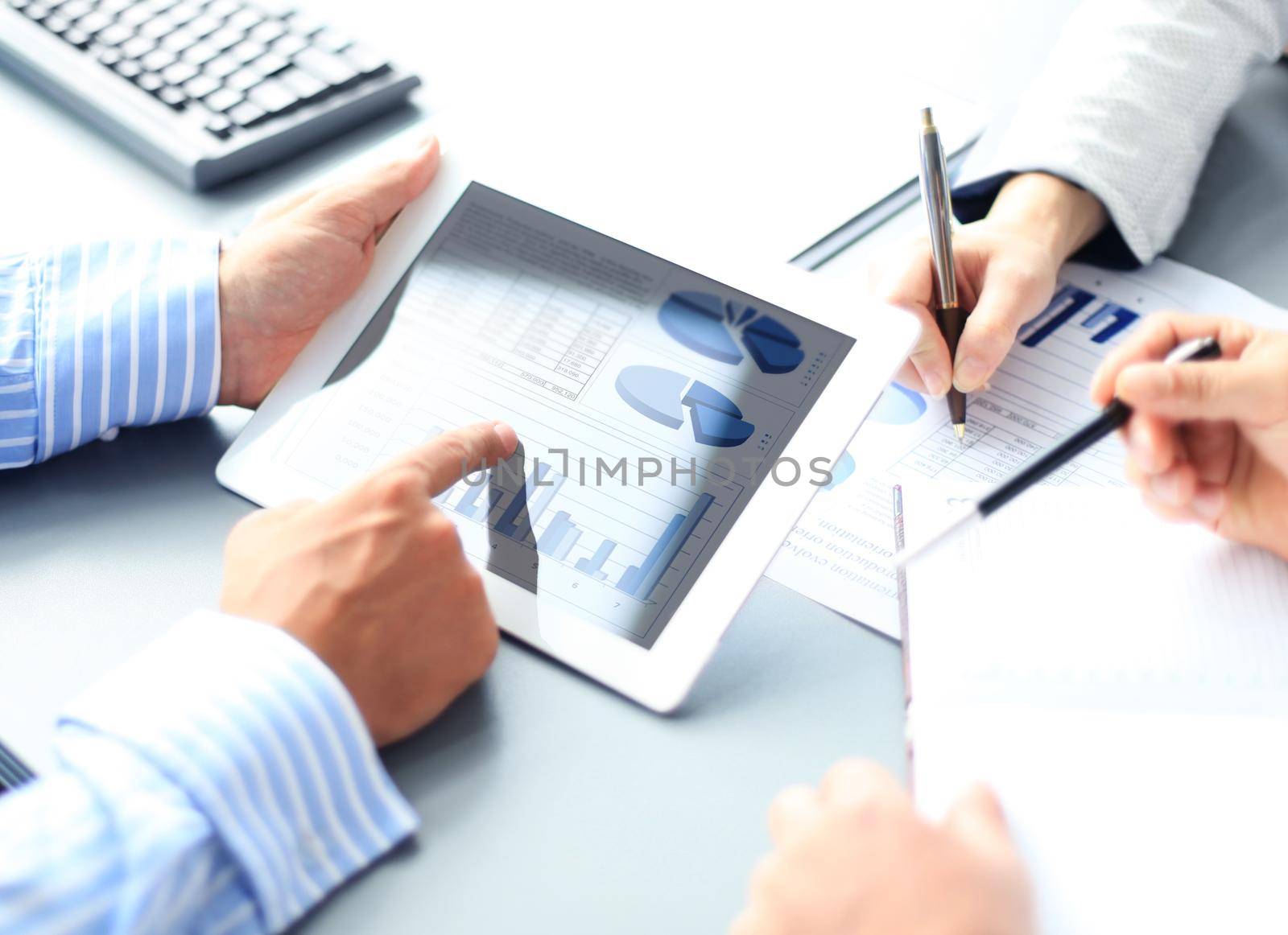 Business person analyzing financial statistics displayed on the tablet screen by tsyhun