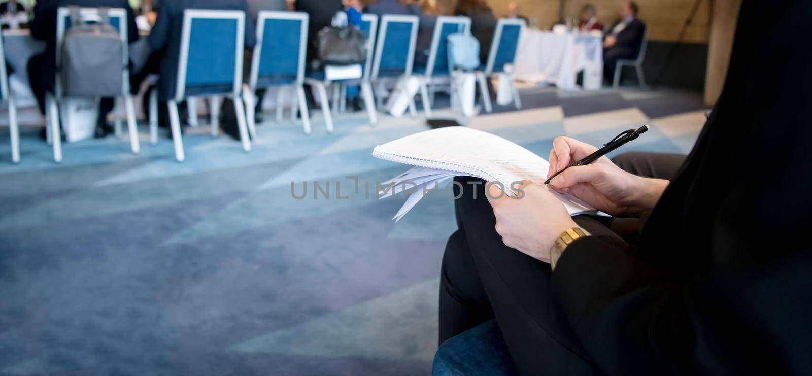 closeup shot of business people hands using pen while taking notes on education training during business seminar at modern conference room