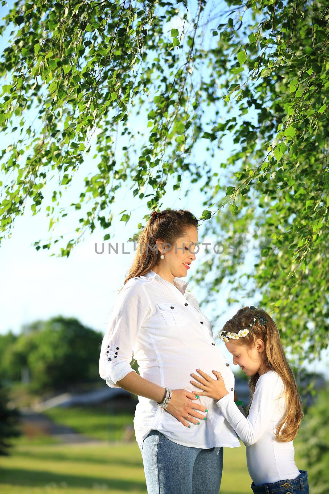 concept of maternity - pregnant mother and little daughter on a by SmartPhotoLab