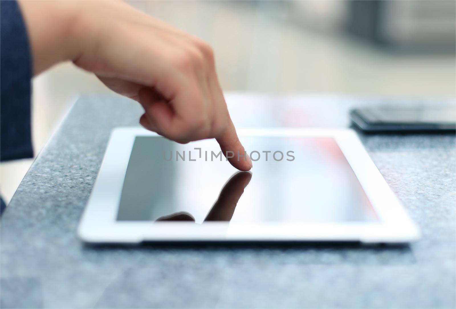 Woman hand touching screen on modern digital tablet pc. Close-up image with shallow depth of field focus on finger. by tsyhun