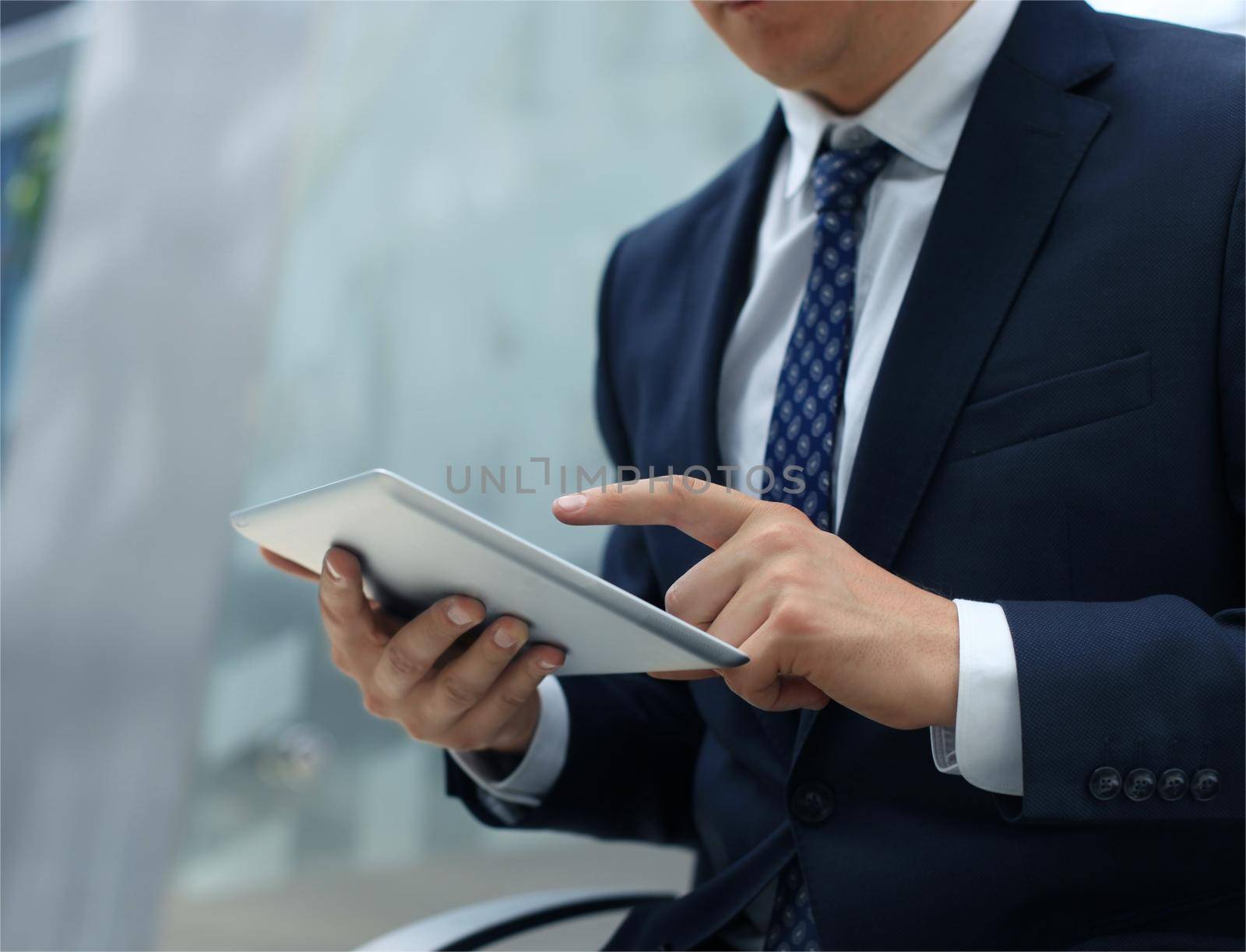 Midsection of businessman using digital tablet in office
