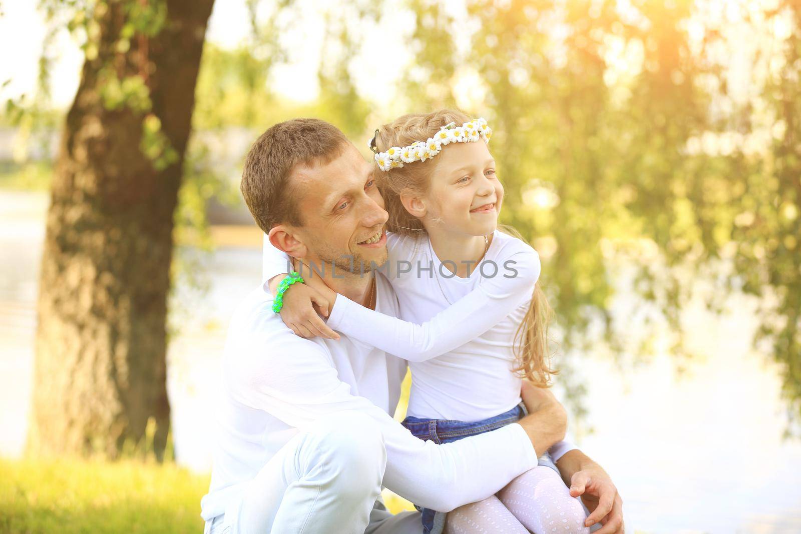 fatherhood - happy father and little daughter hugging each other in the Park on a Sunny day