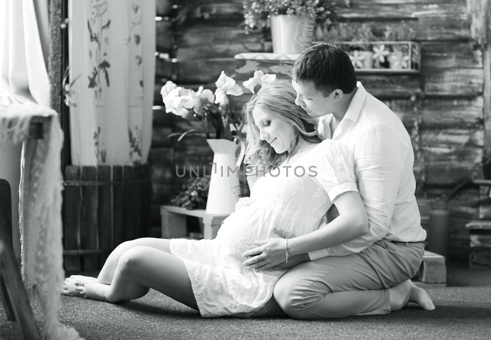 Portrait of a happy couple - husband and pregnant wife, black-and-white photo