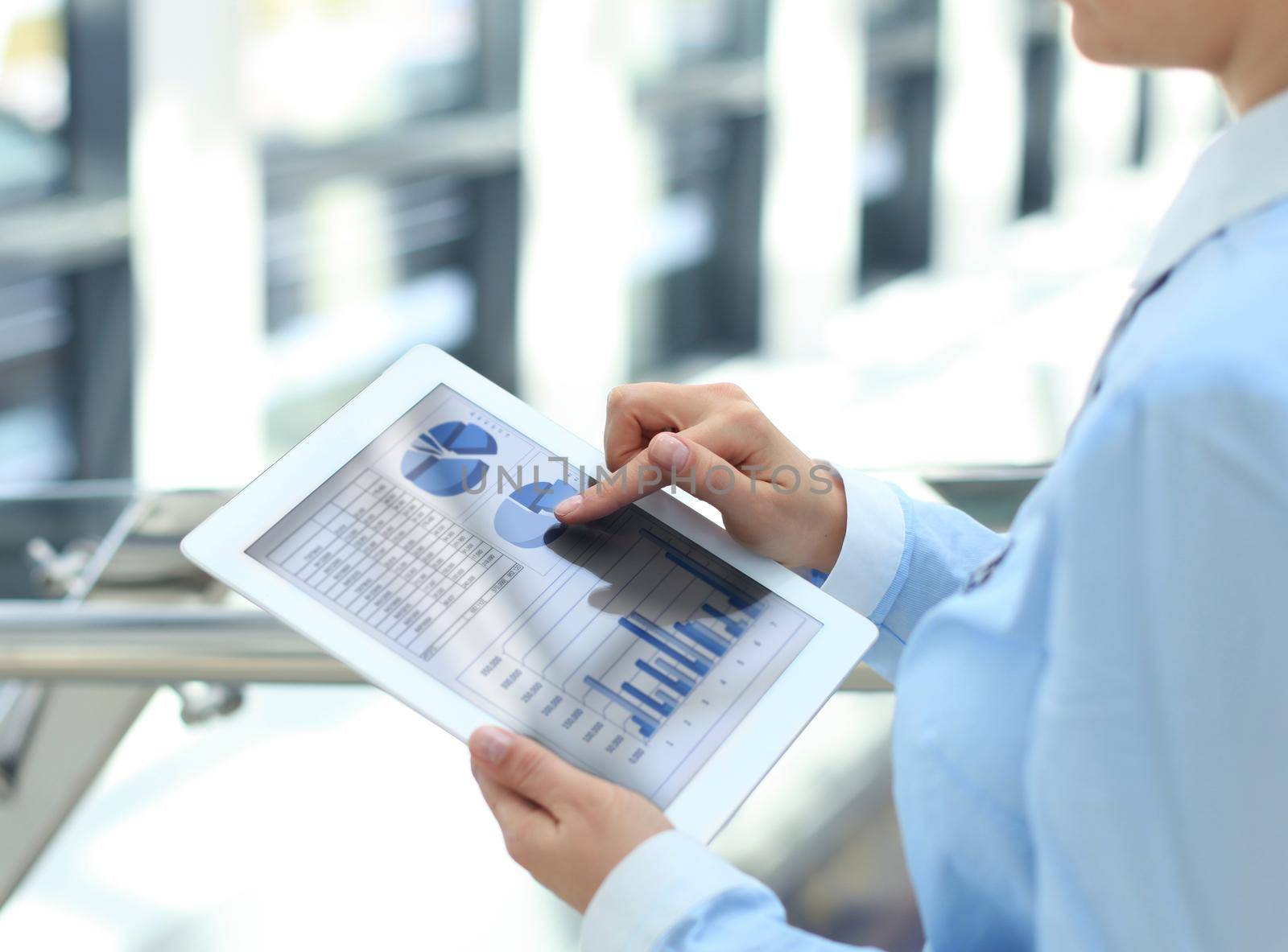 Business person analyzing financial statistics displayed on the tablet screen