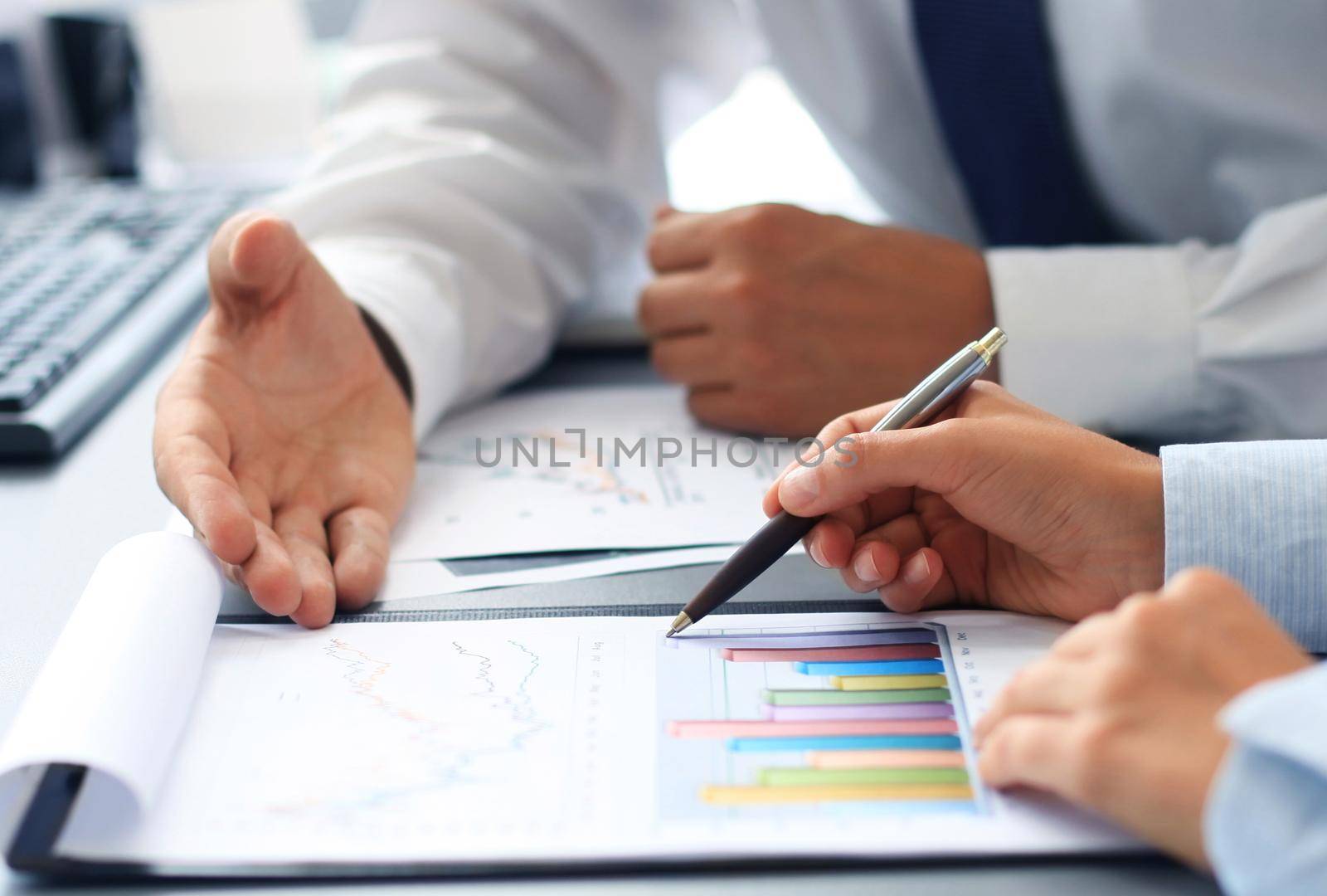 Unrecognizable business person analyzing graphs and taking notes