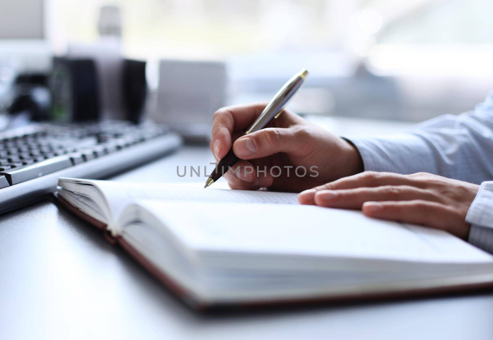 Businesswoman makes a note in notebook.